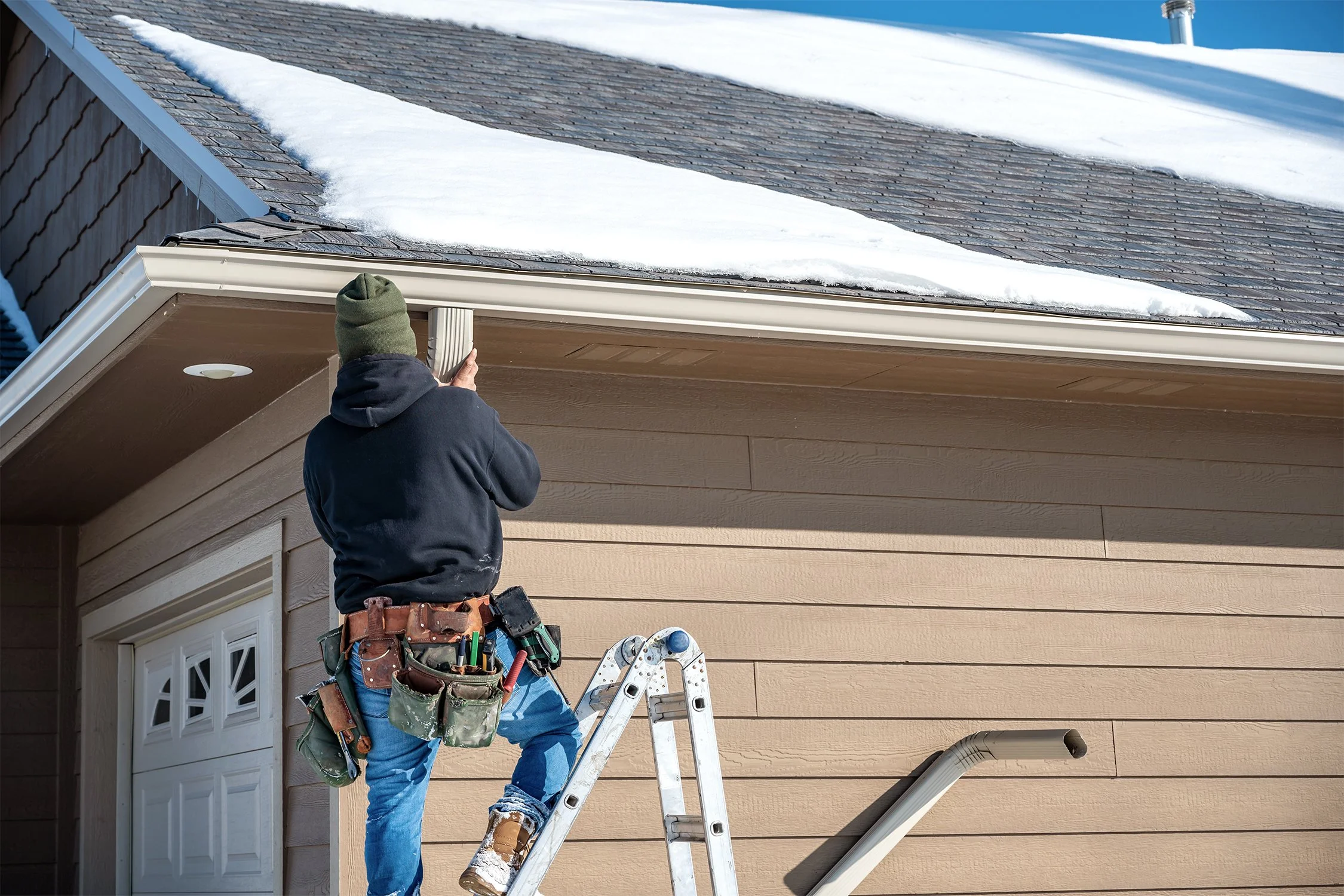 Home contractor installing new gutter system on a home.
