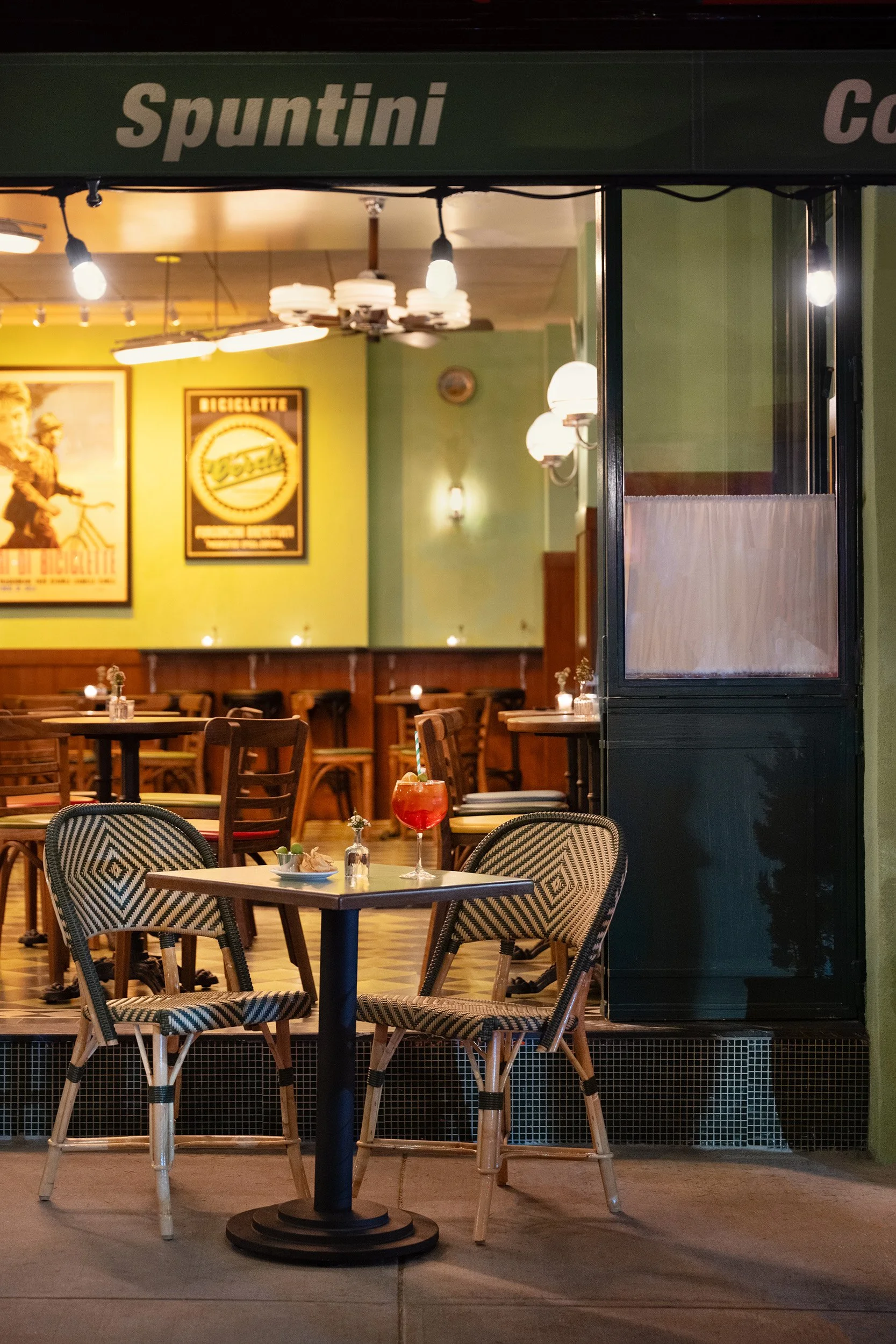 Exterior of Bar Bianchi showing table and two chairs with aperol spritz and bites