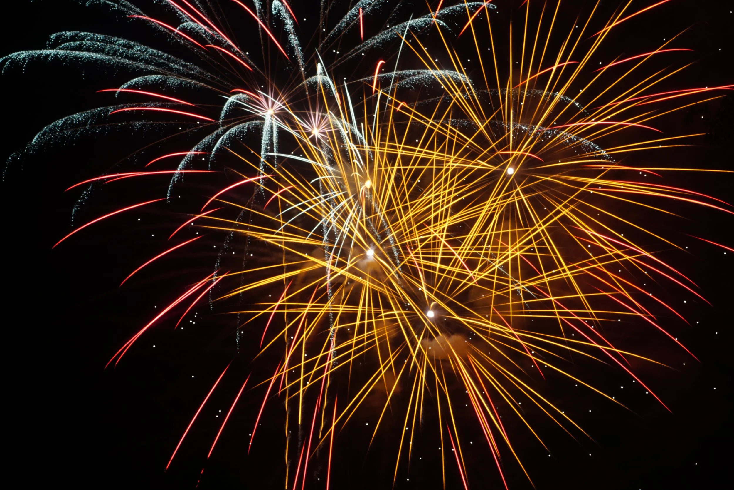 Overhead view of a black metal spiral staircase with diamond plating steps set against a red background.