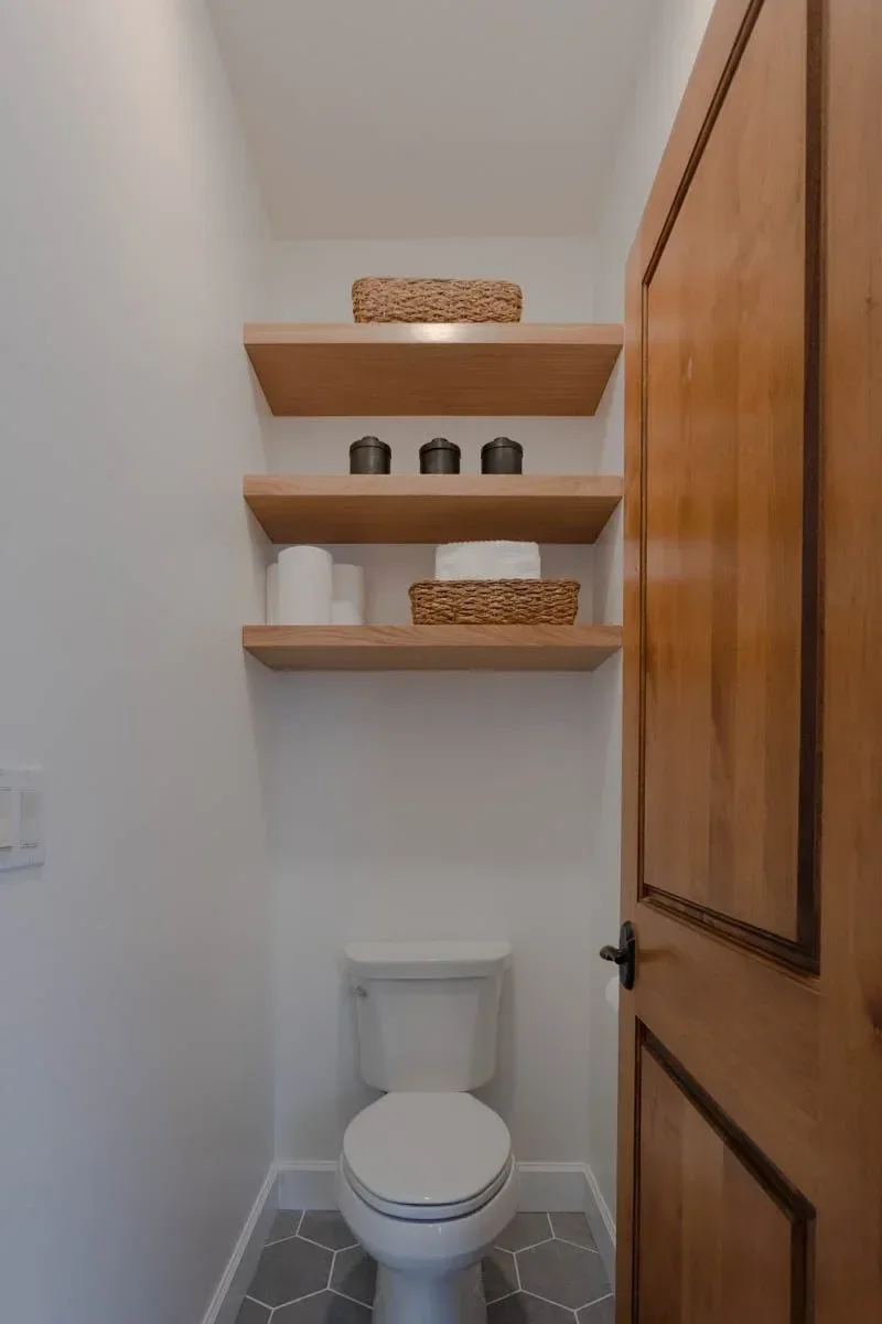 Modern home renovation featuring warm wood cabinetry, hex tile flooring, textured shower walls, and neutral-toned interiors in Southern Oregon, completed by Verity Construction.