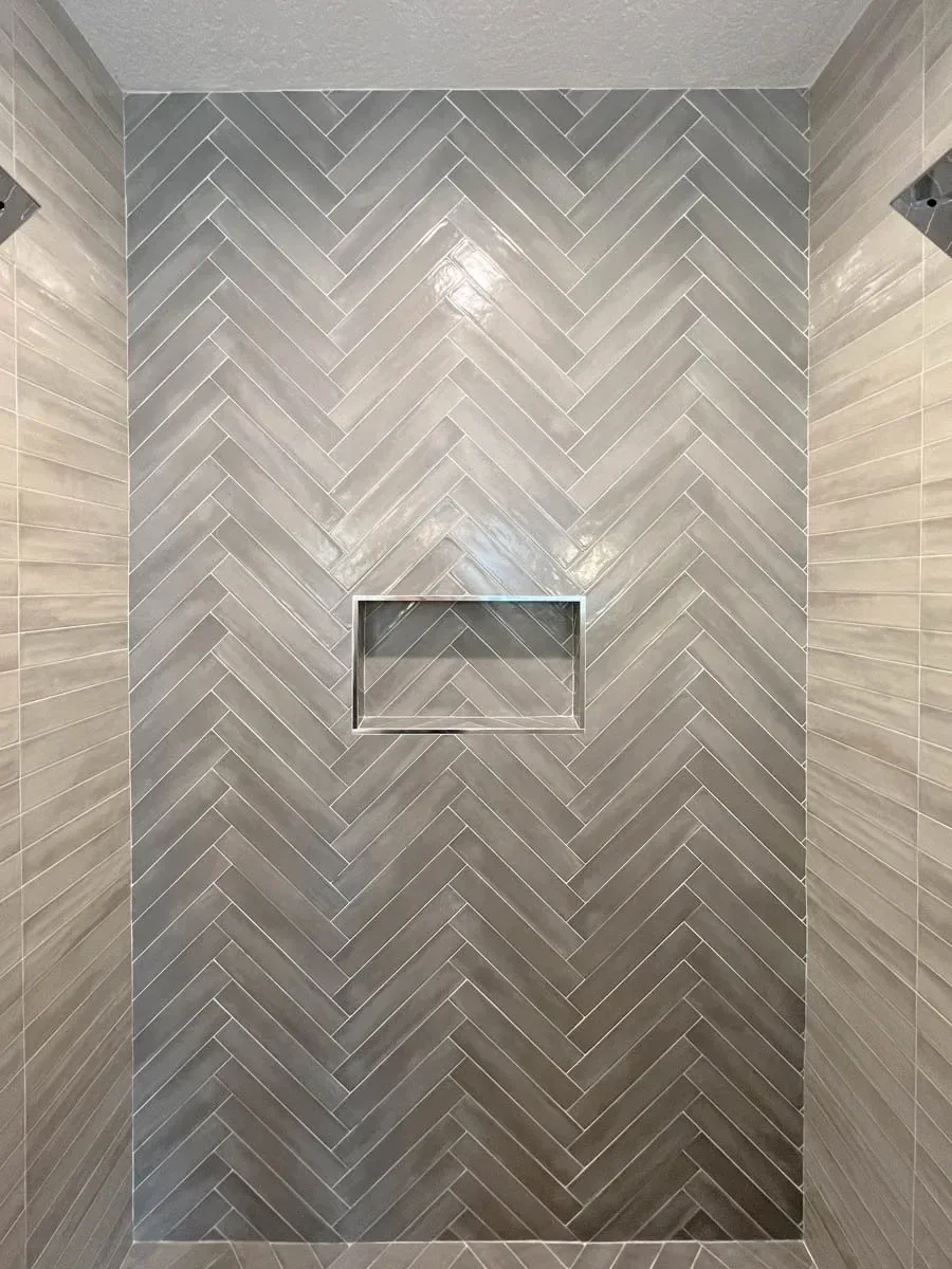 Modern home renovation featuring warm wood cabinetry, hex tile flooring, textured shower walls, and neutral-toned interiors in Southern Oregon, completed by Verity Construction.