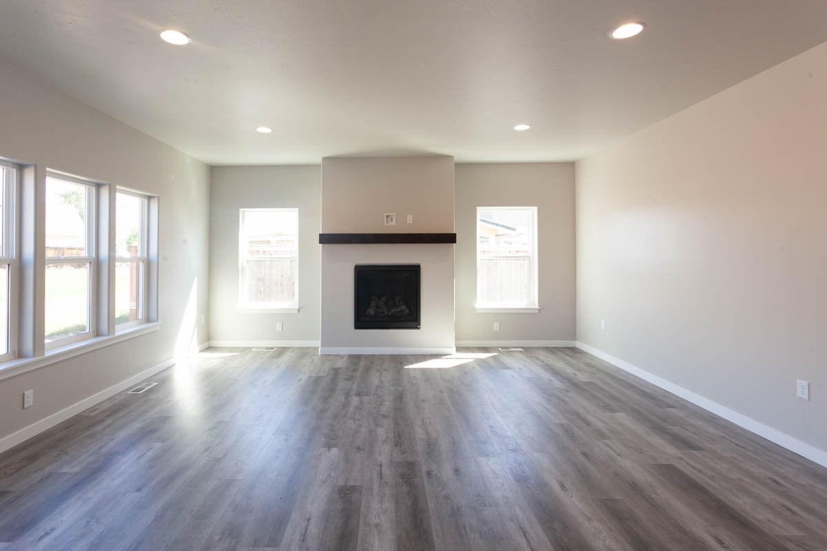 Spacious Southern Oregon living room remodel with fireplace and large windows.