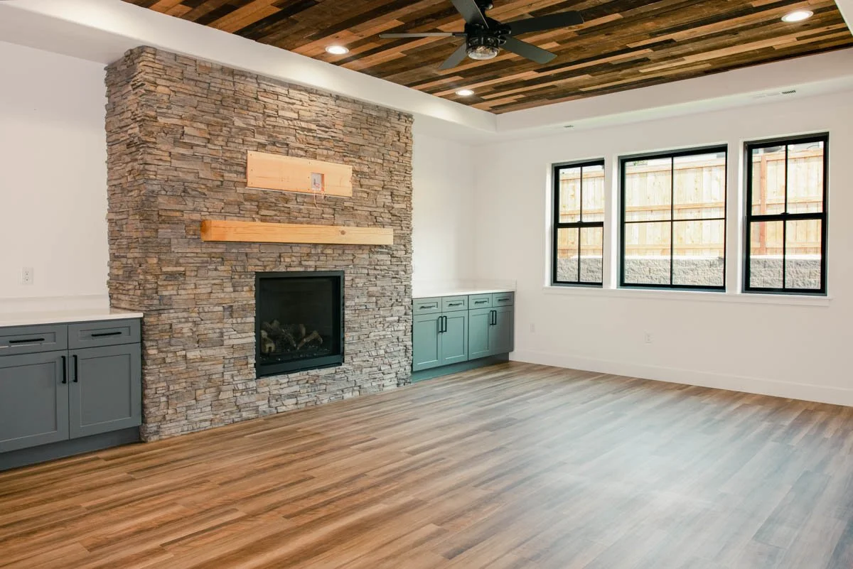 Living room remodel featuring a stone fireplace, completed in Medford by Verity Construction.