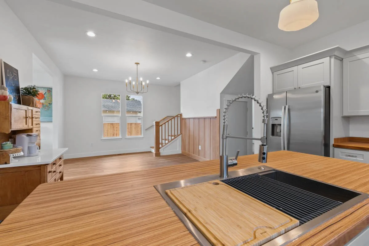 Modern kitchen island with custom wood countertop and inset sink, designed by Verity Construction in Southern Oregon.