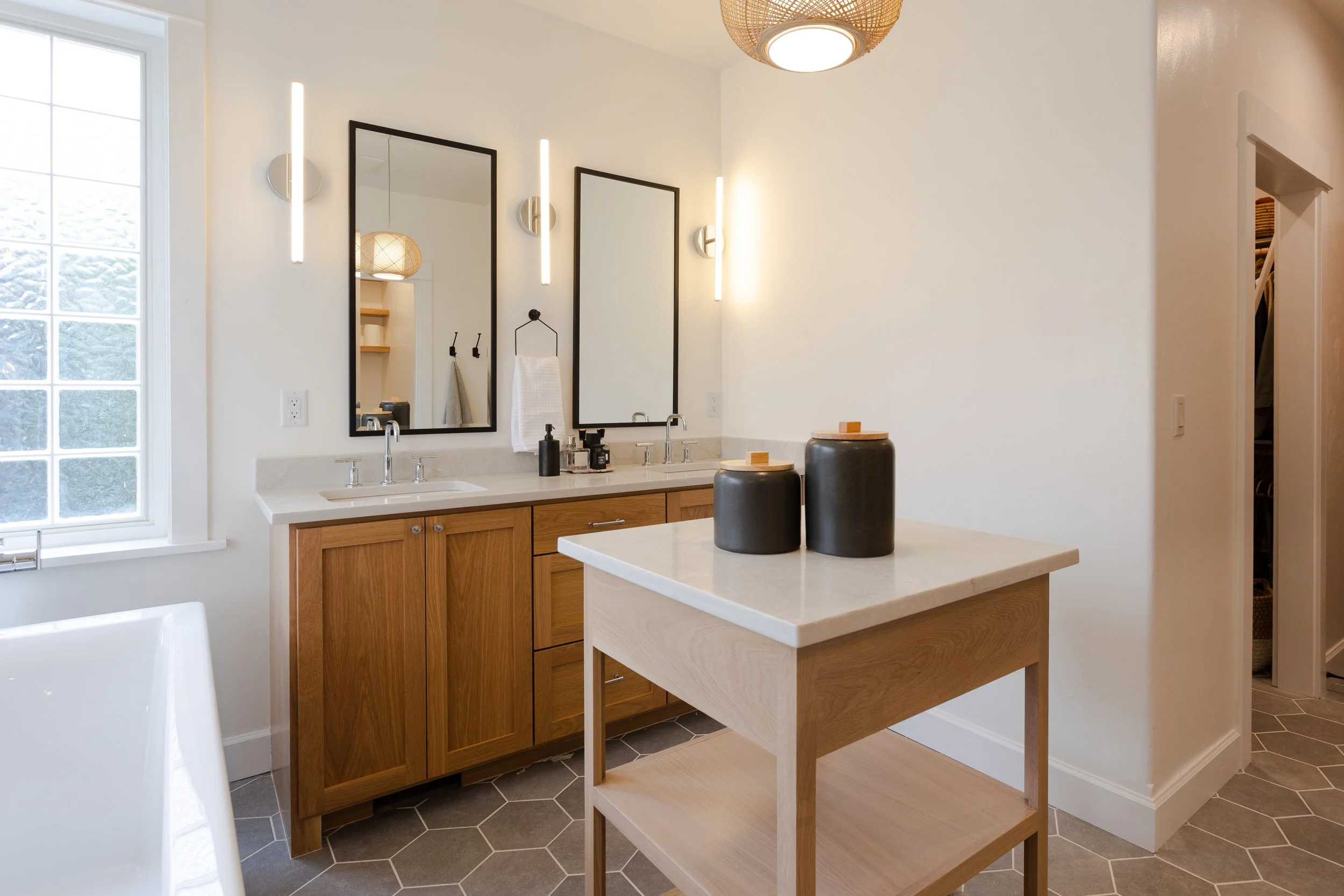 Modern bathroom remodel by Verity Construction featuring warm wood vanity and minimalist lighting in Southern Oregon.