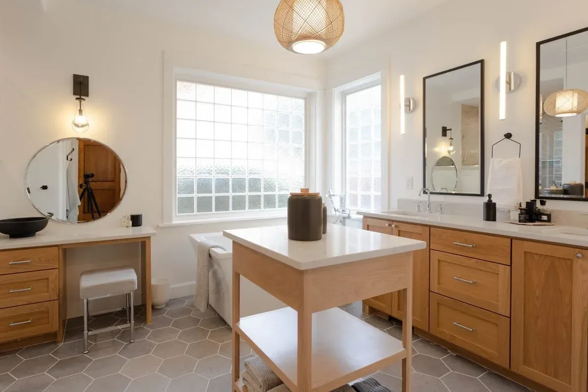 Modern home renovation featuring warm wood cabinetry, hex tile flooring, textured shower walls, and neutral-toned interiors in Southern Oregon, completed by Verity Construction.