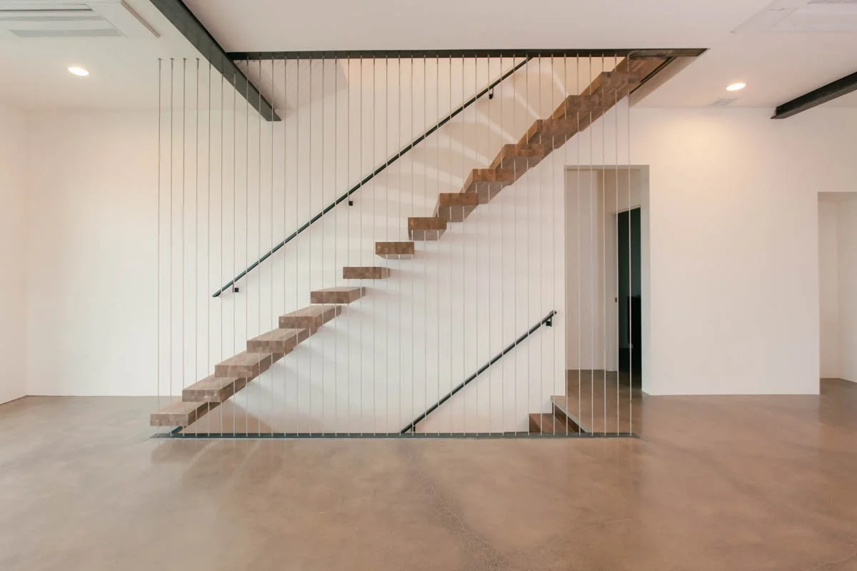 Floating staircase with vertical cable railing in modern home by Verity Construction in Southern Oregon.