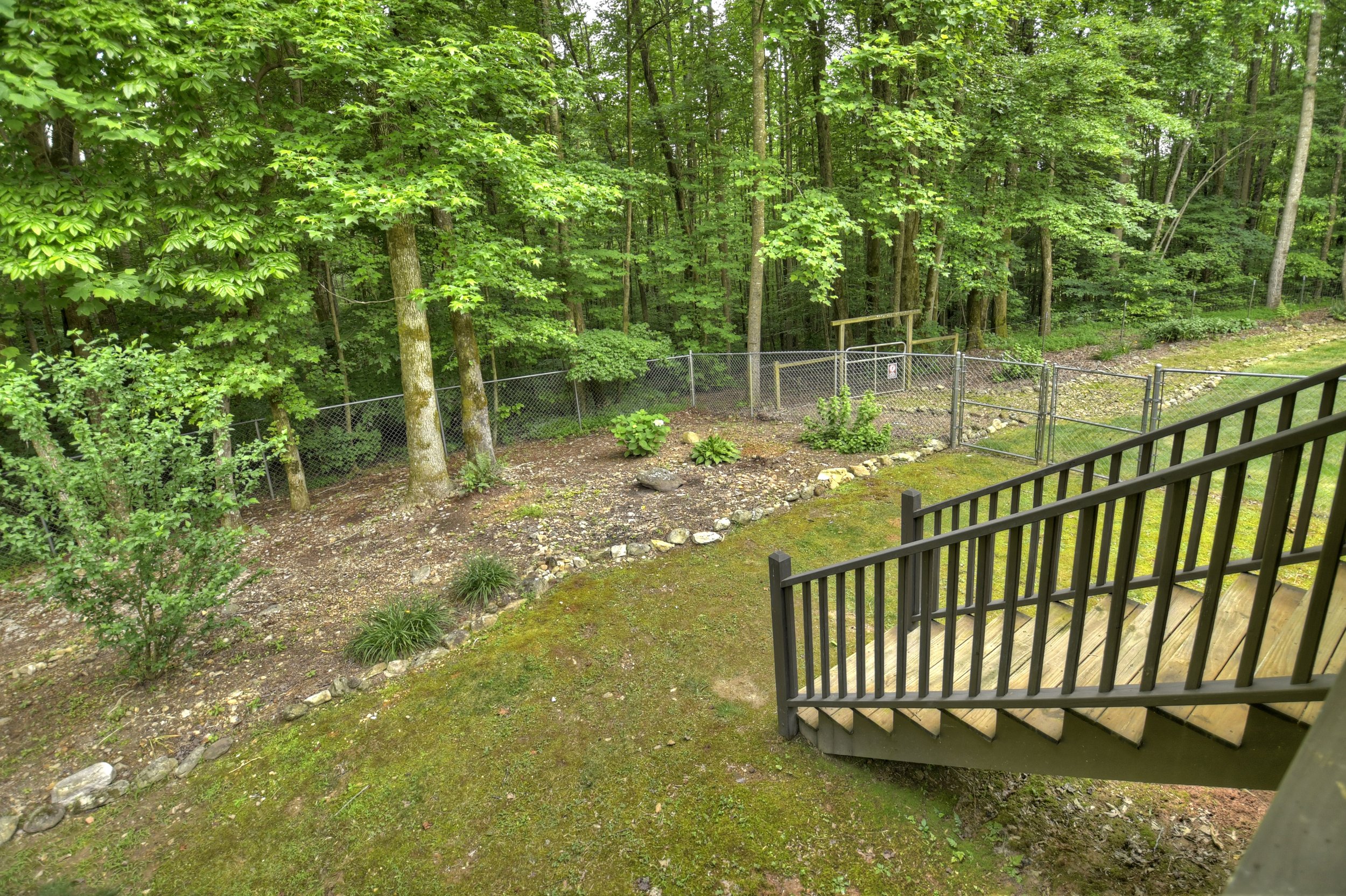 Fully fenced backyard off the back deck, providing a secure space for pets and guests to relax, play, and enjoy the peaceful natural surroundings.