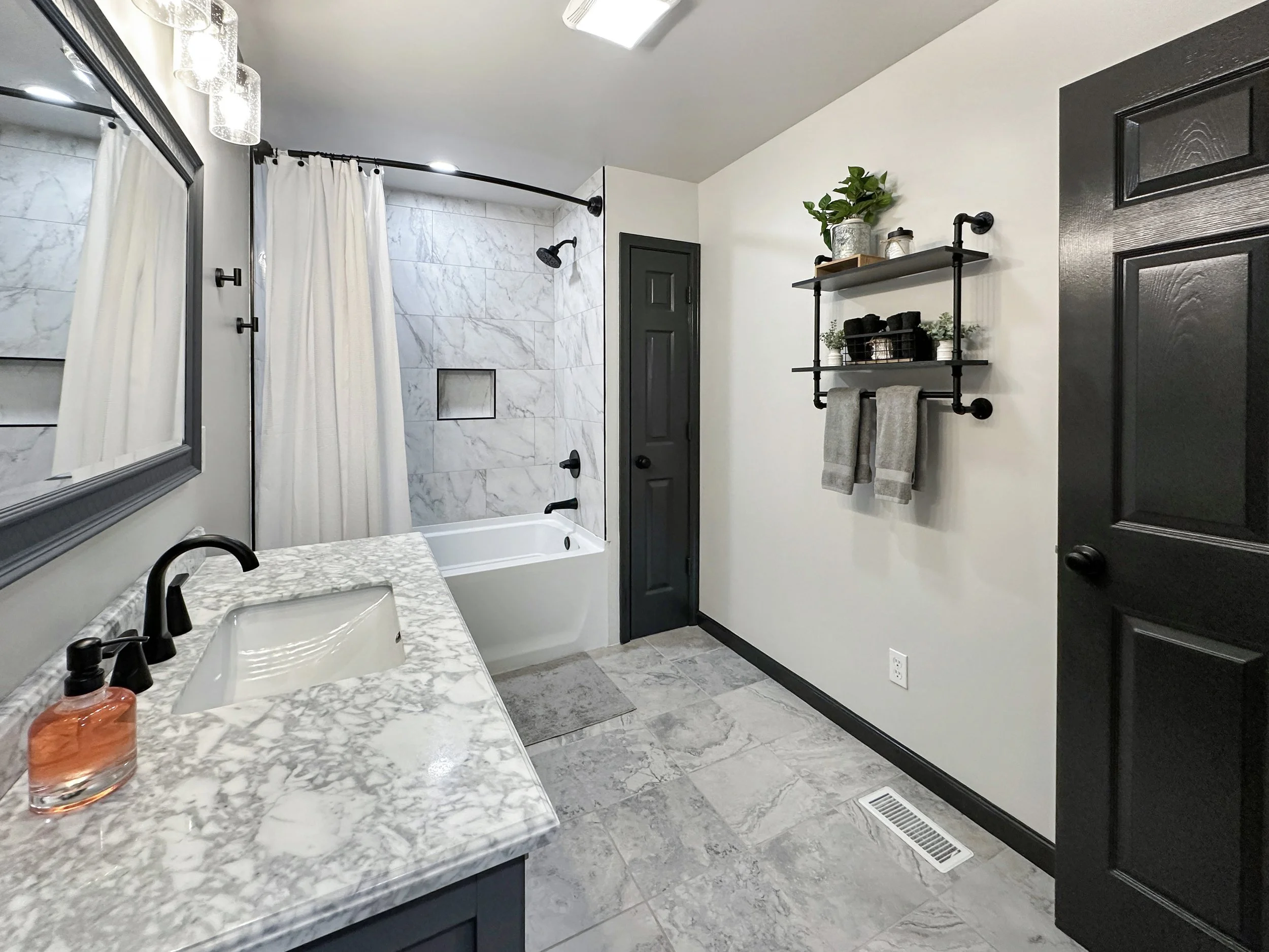 Modern second bathroom with a tub / shower surround, sleek vanity, and bright lighting. Designed for comfort and convenience with stylish finishes and essential amenities.