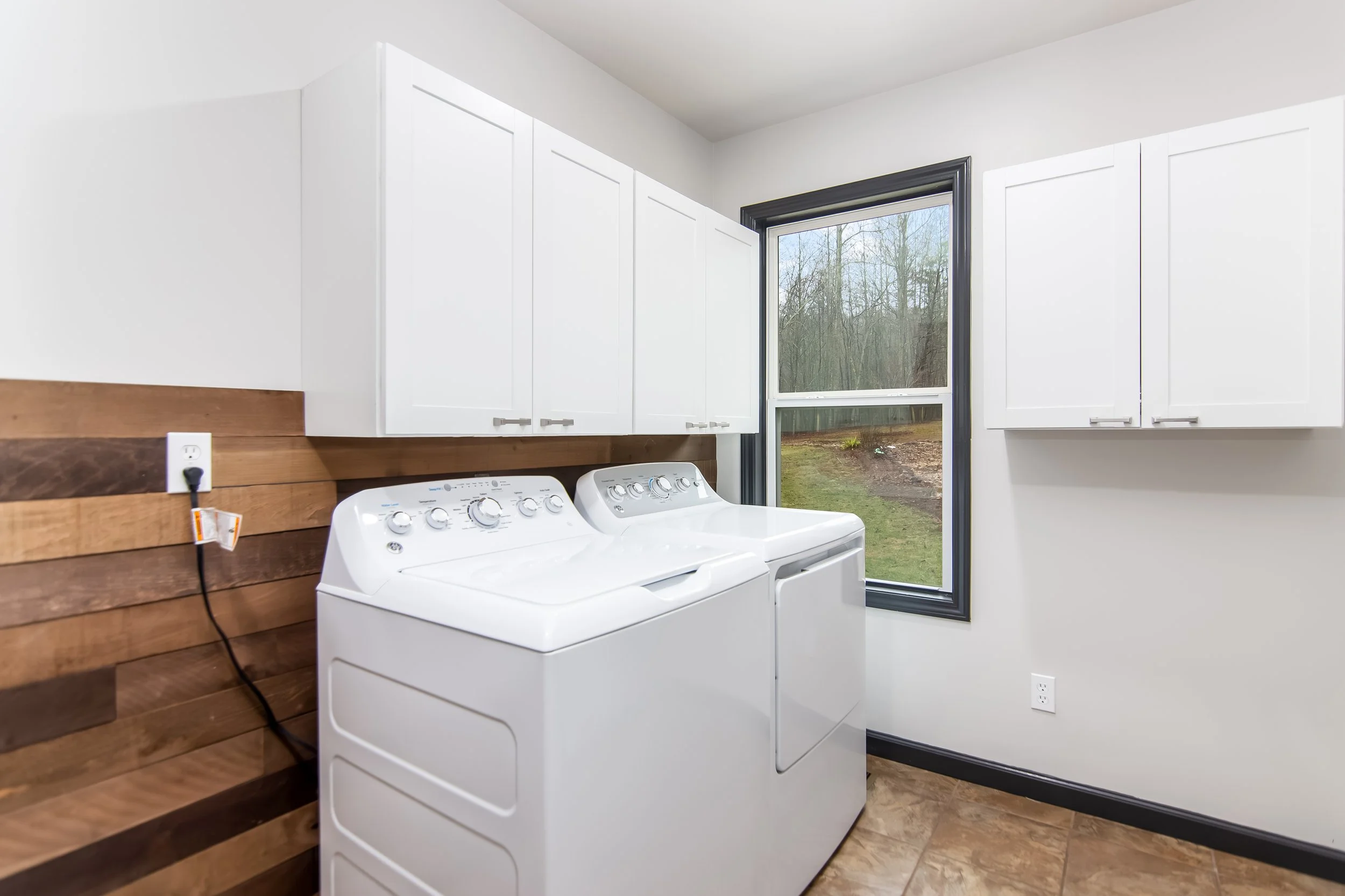 Fully equipped laundry room with a washer, dryer, storage shelves, and ample space for convenience during your stay.