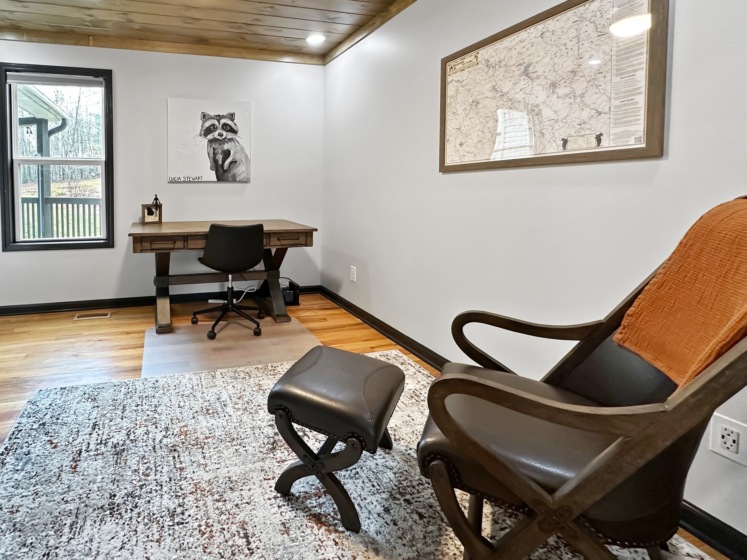 Dedicated office space with a full-sized desk, ergonomic chair, and high-speed WiFi, offering a quiet and comfortable workspace with serene forest views.