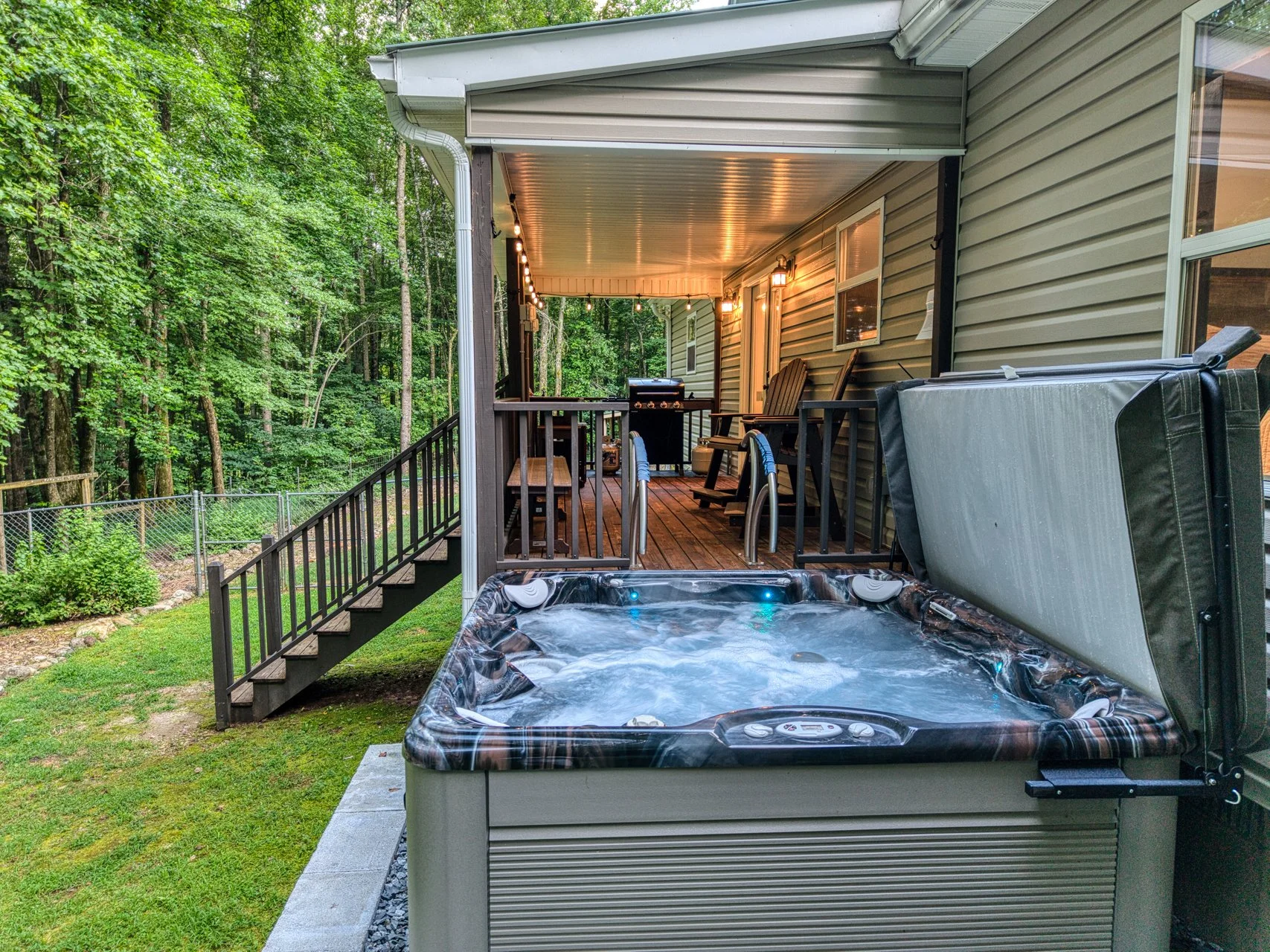 pacious 7-person hot tub on the covered deck, offering the perfect place to relax and unwind while enjoying the serene forest surroundings.