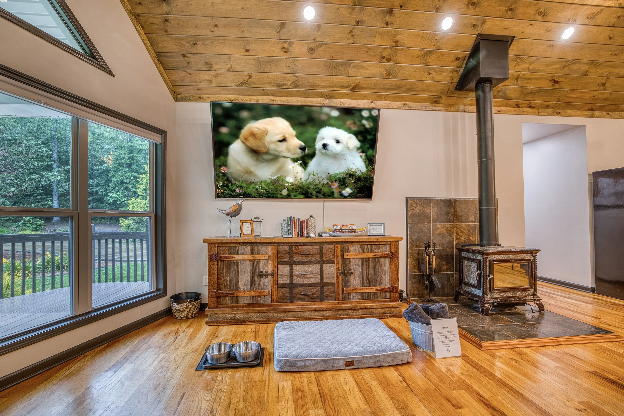 Dedicated dog-friendly area with bed, bowls, and wood stove for cozy pet stays.