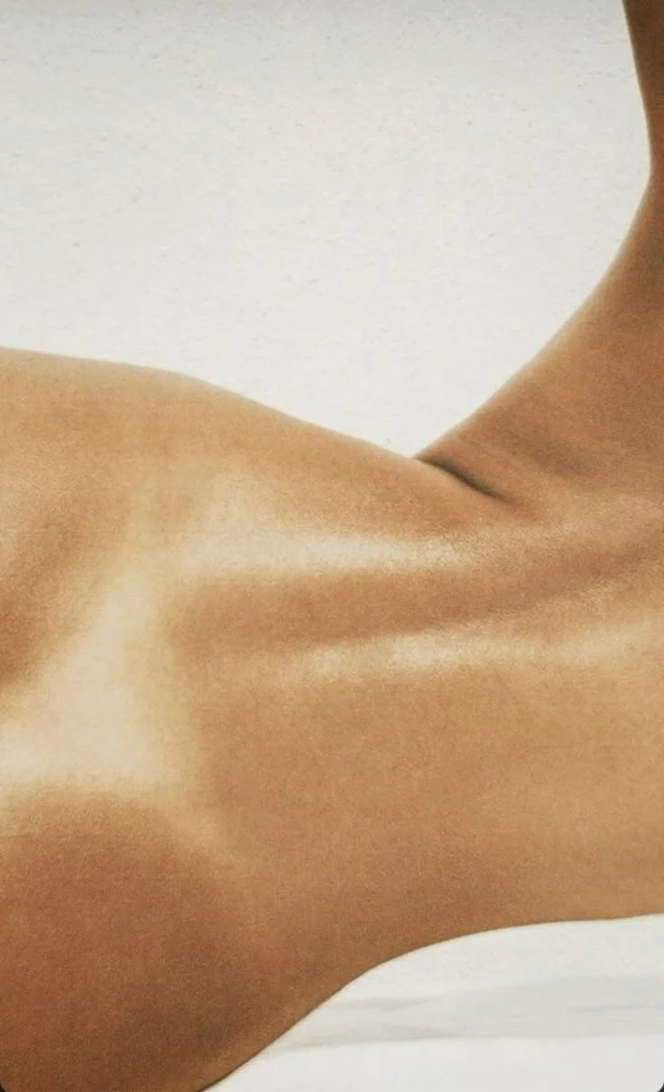 Close-up of a person's bare back and shoulder, showing smooth skin and contours.