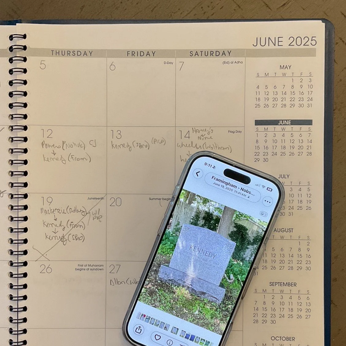 Monthly calendar with phone on top showing a gravestone