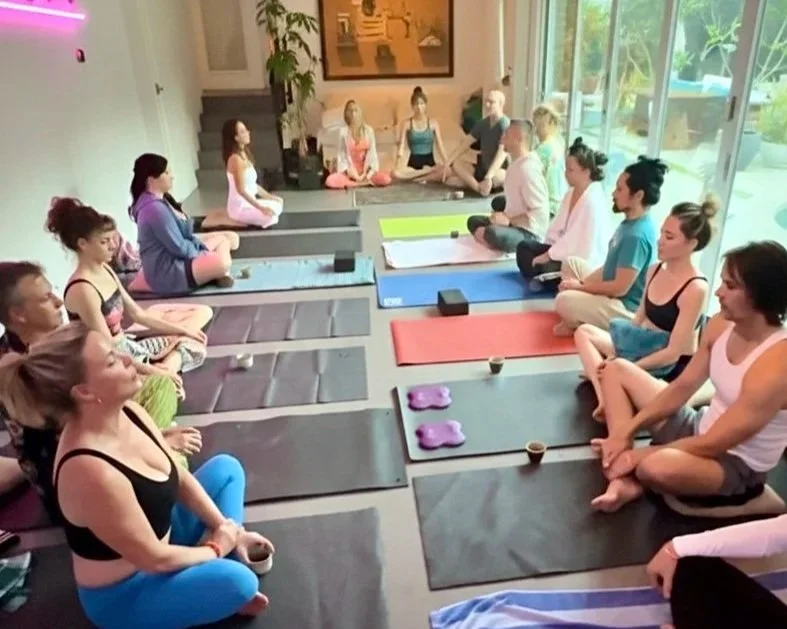 Group of people practicing yoga in a bright indoor space