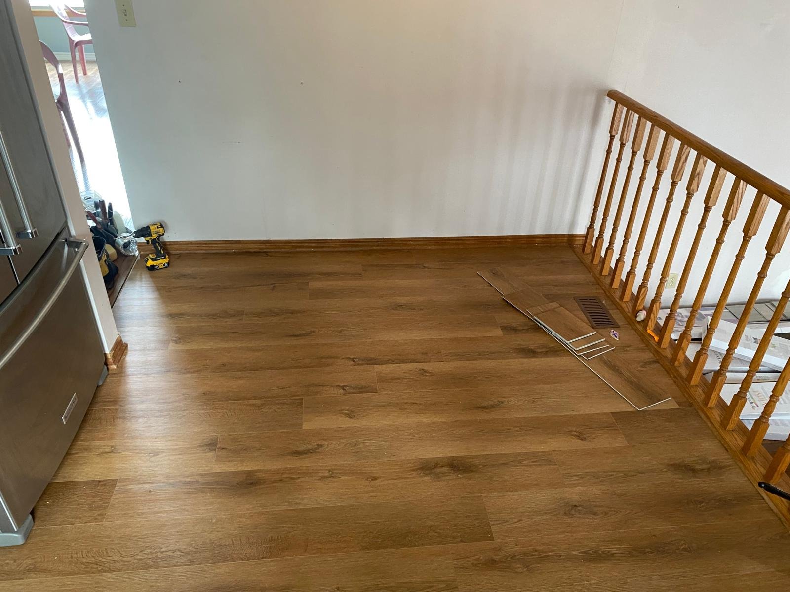 Room with hardwood flooring, a railing, and tools on the floor.
