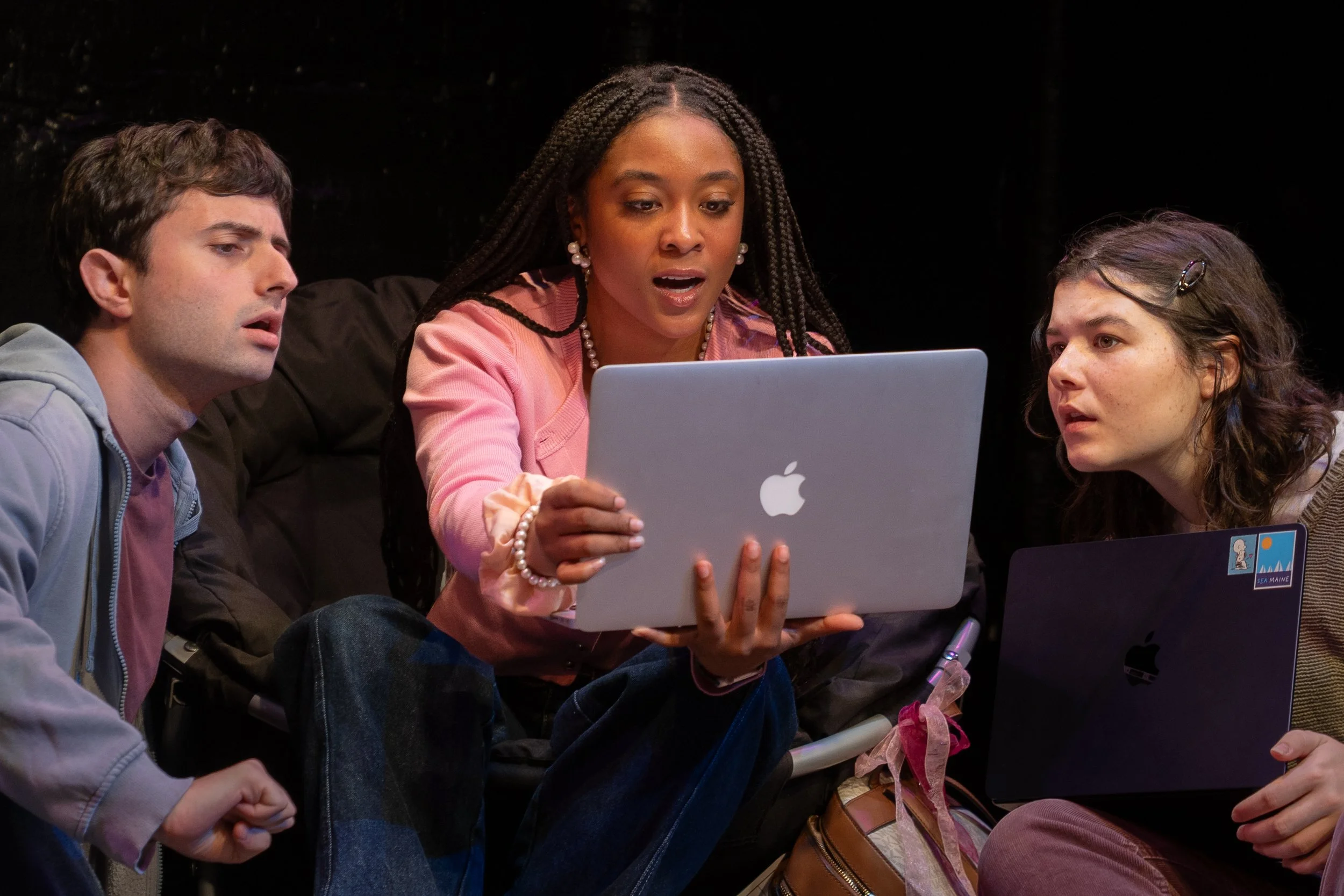 Remidy Destyn Dixon in "In Chief" - Three young women and one young man sitting closely together, looking at a laptop screen with surprised or focused expressions.