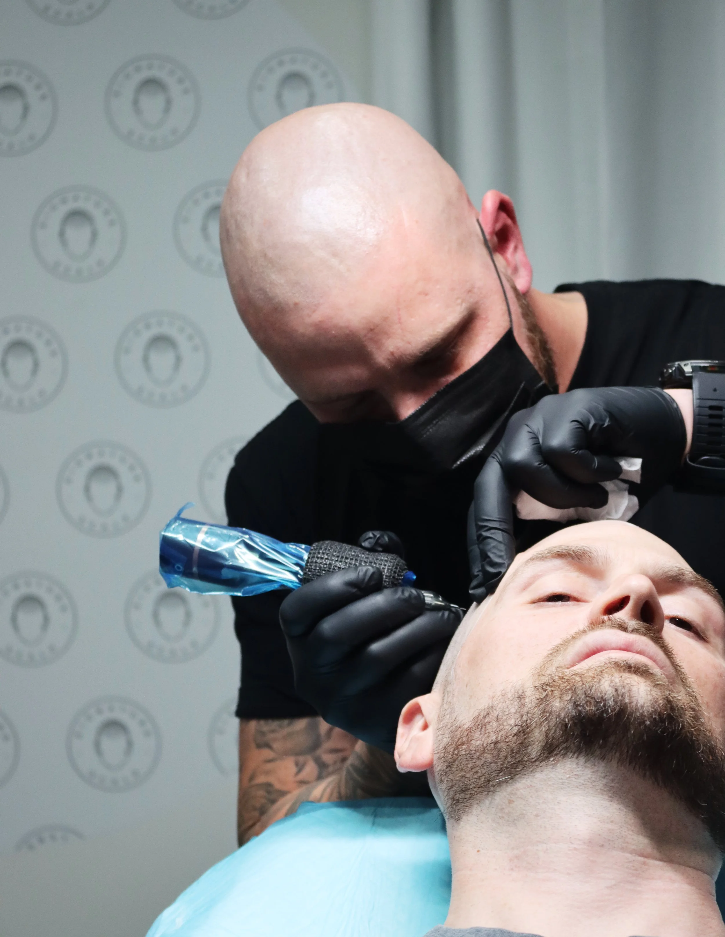 Signature Scalp Adelaide SMP artist performing scalp micropigmentation treatment on a male client at Marden studio