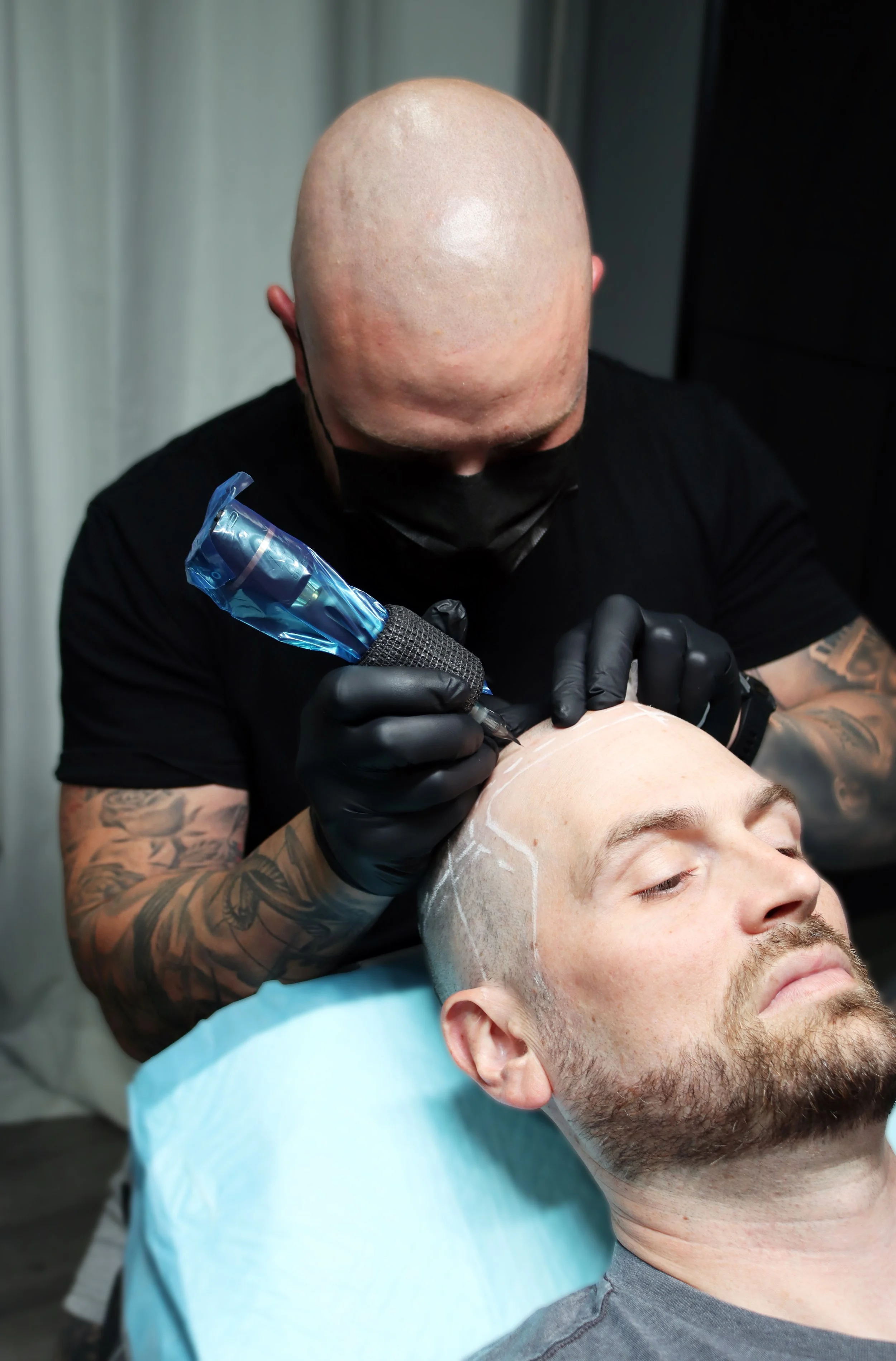 Signature Scalp Adelaide SMP artist performing scalp micropigmentation treatment on male client at Marden studio