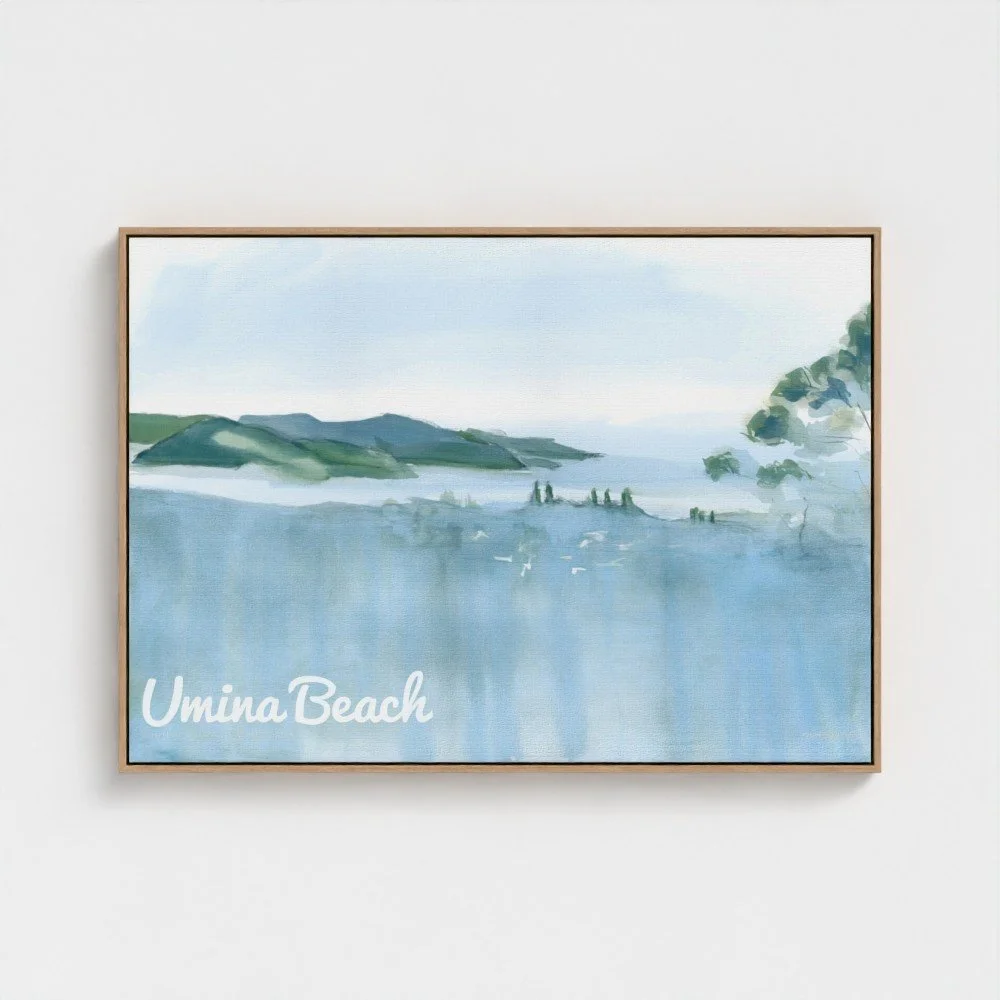 A framed watercolor painting of Umina Beach with hills, water, sky, and trees, with the text "Umina Beach" in the lower left corner.