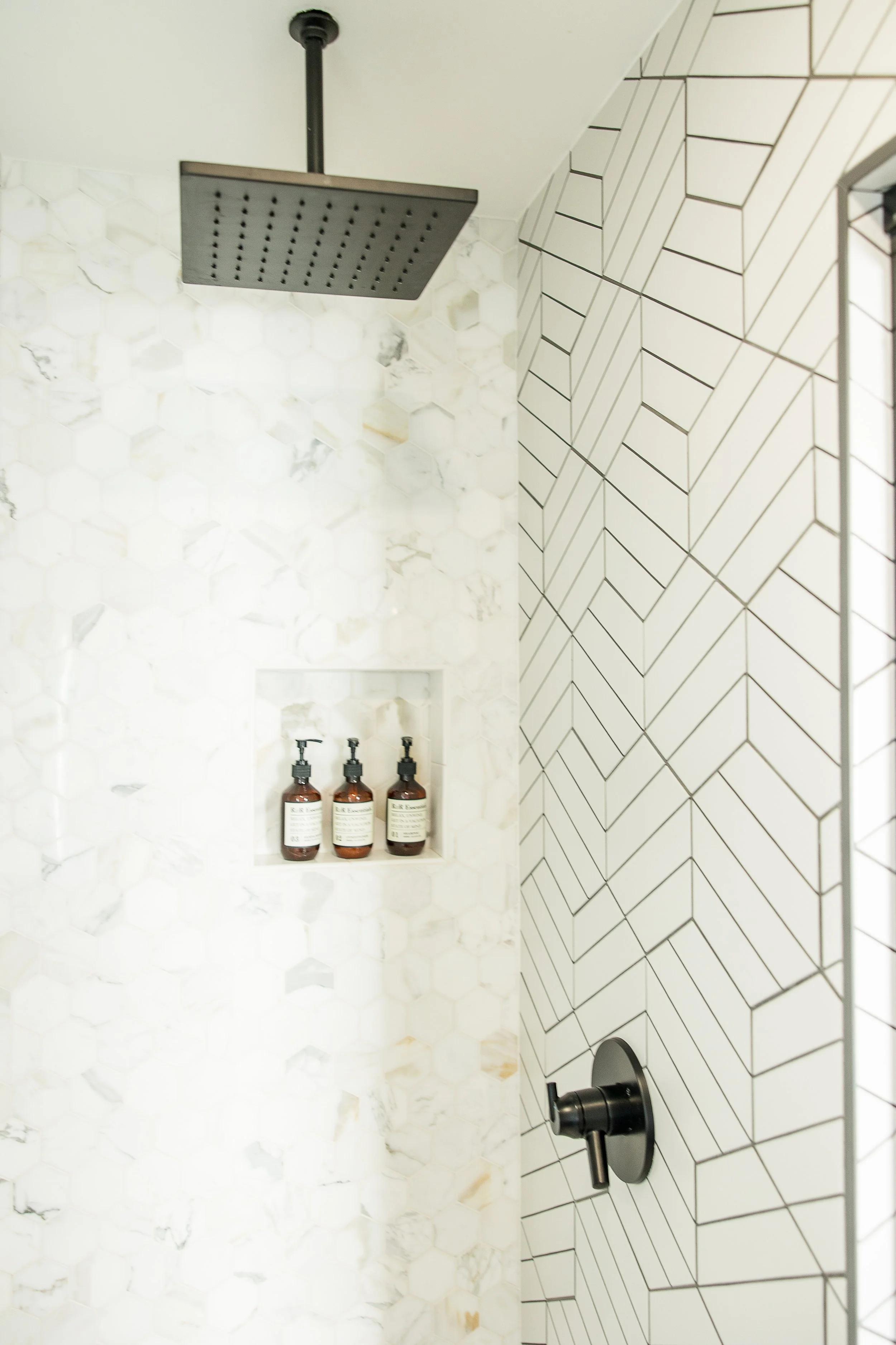 Wide-angle interior of an Osprey cabin at Dillon Beach Resort showing high vaulted ceilings with dark wood beams, industrial pendant lighting, a modern kitchenette, and large windows leading to a private deck.