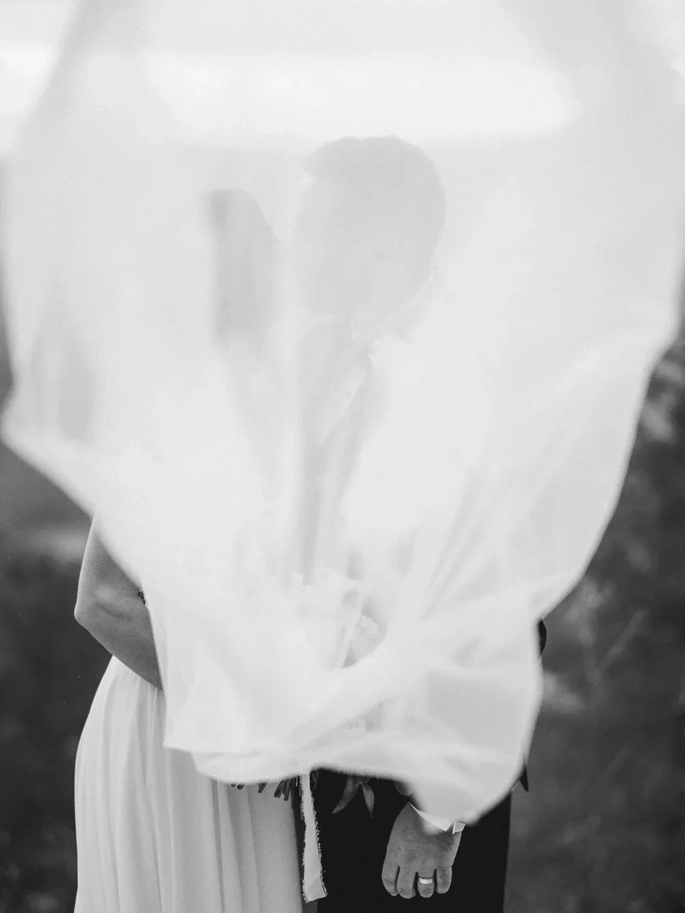 Bride and groom walking arm in arm during golden hour at their Knoxville wedding, captured in an elegant, timeless style