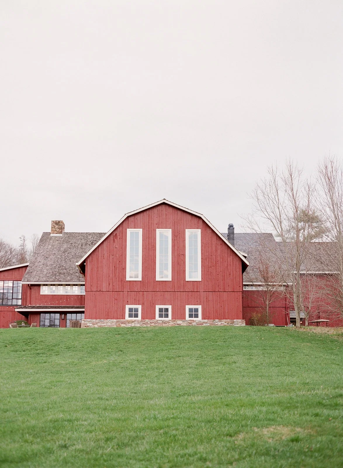 The red barn farmhouse at Blackberry Farm in the Smoky Mountains, a luxury Tennessee wedding venue surrounded by rolling green hills
