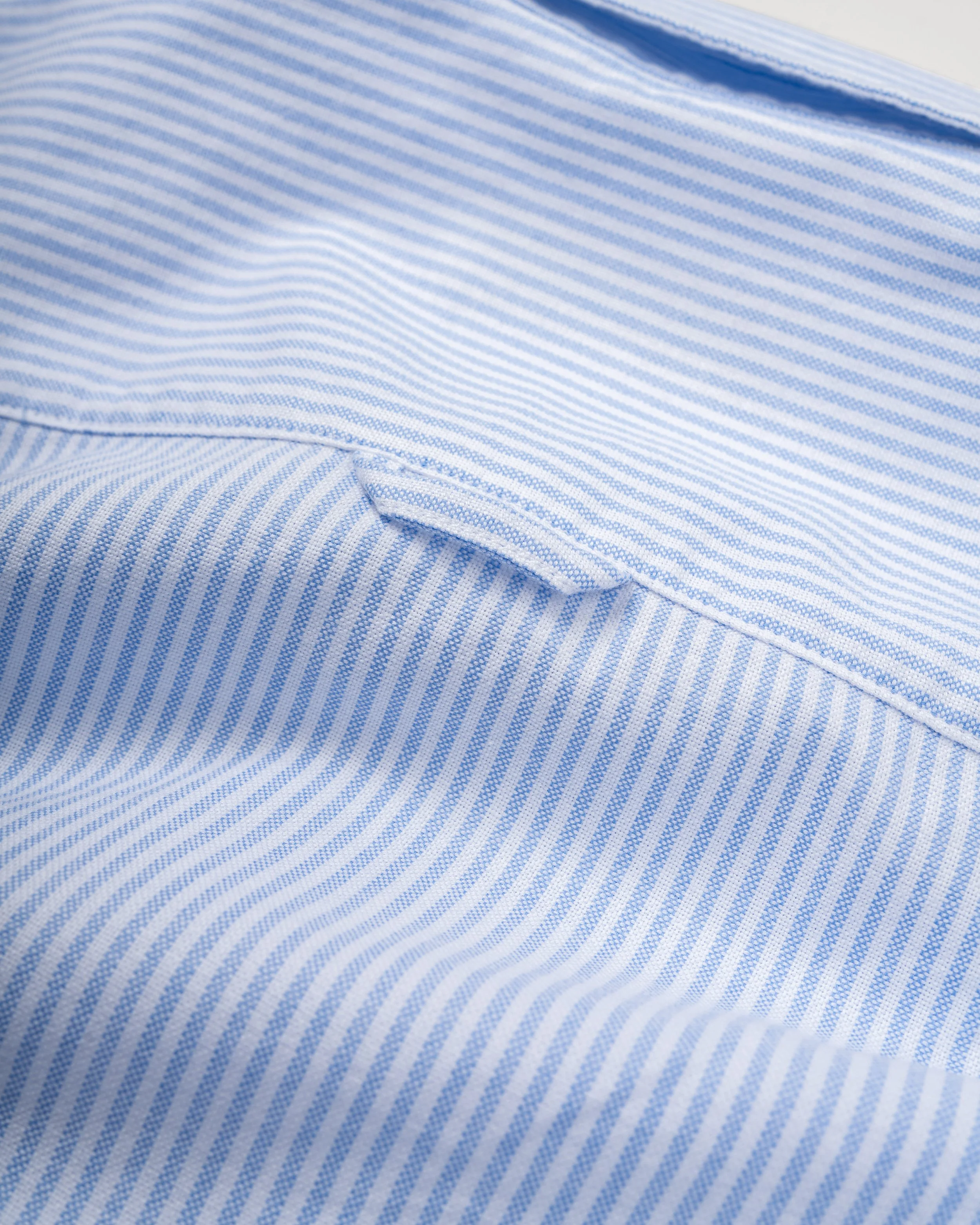 Nahaufnahme eines blauen und weißen gestreiften Stoffes mit Falten.