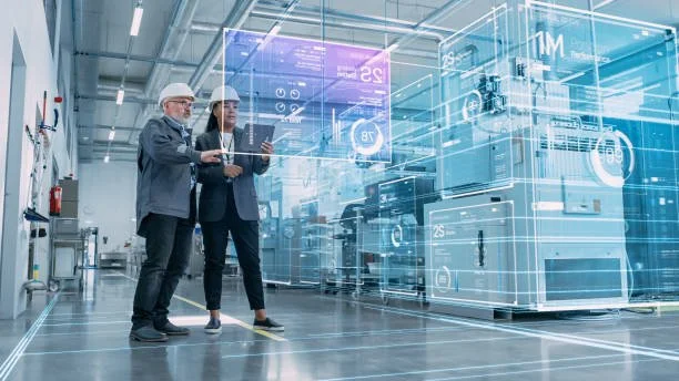 Two professionals wearing safety helmets and formal attire in a high-tech manufacturing or research facility, analyzing digital holographic displays and futuristic machinery.