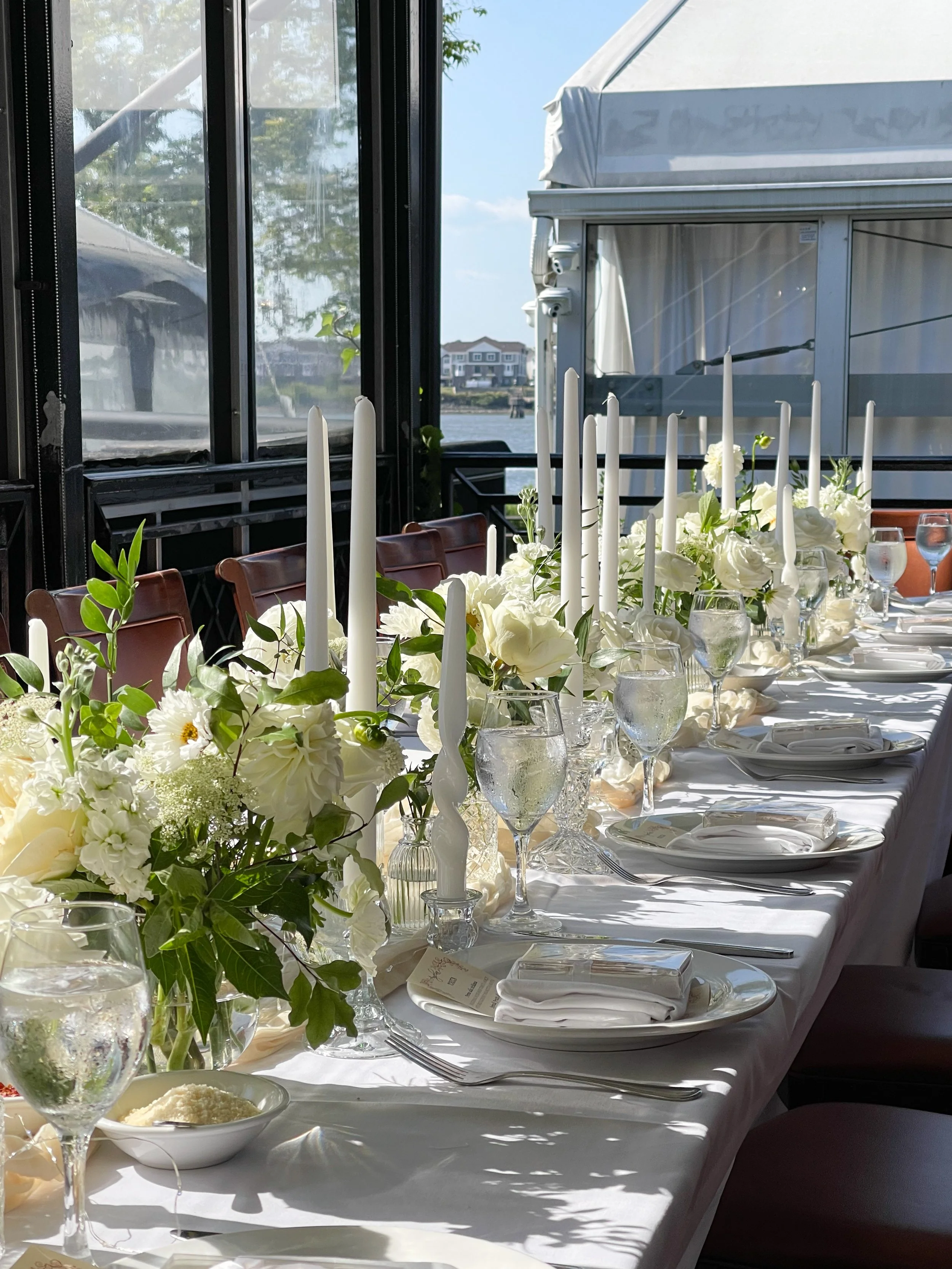 Springy table setting with white and green florals in bud vases