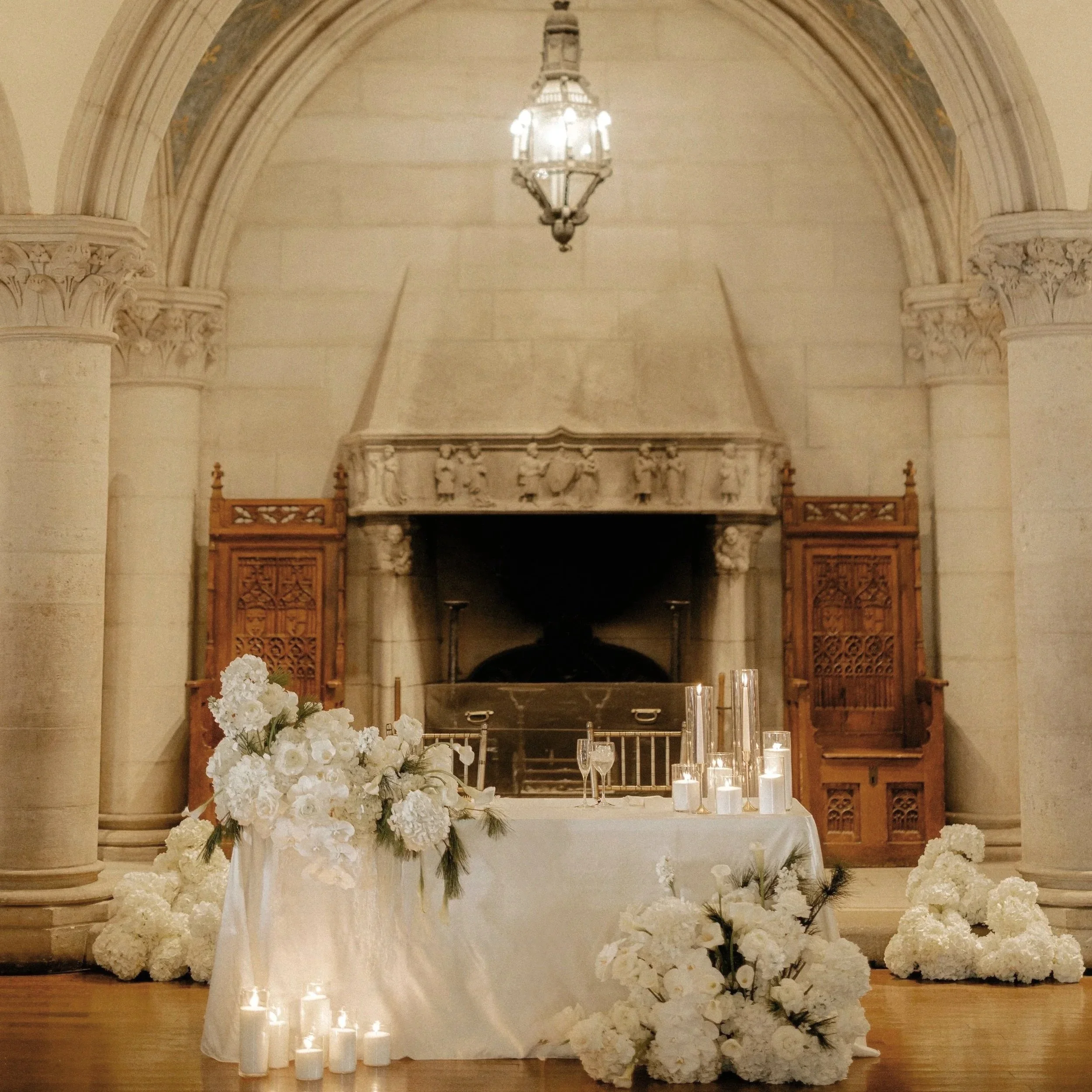 Sweetheart table in a church featuring stunning white flowers