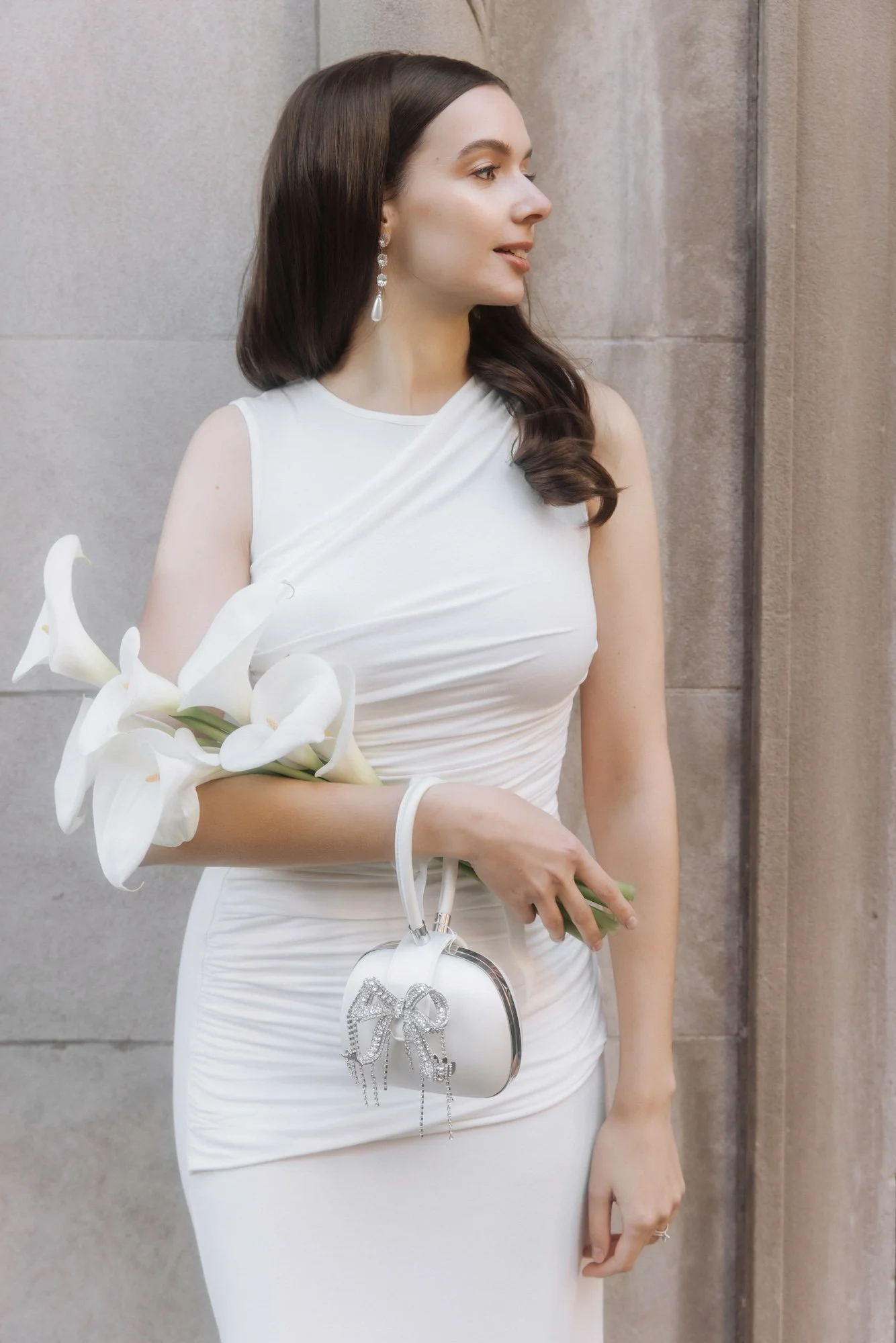 Bride in a white dress holding a classic and elegant bouquet of large white calla lilies