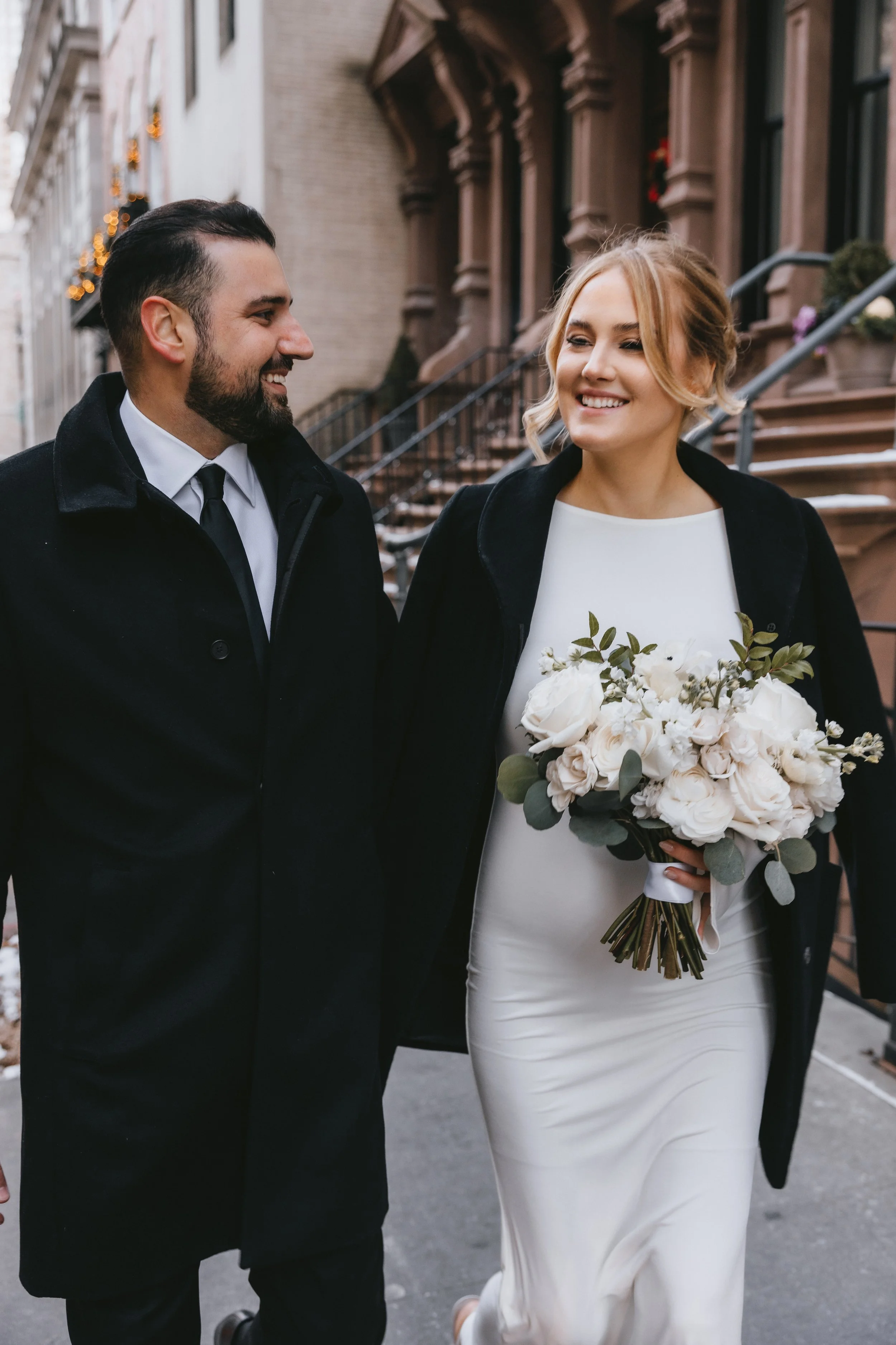 Photo of winter wedding. Bride is carrying hand-tied bouquet of white flowers