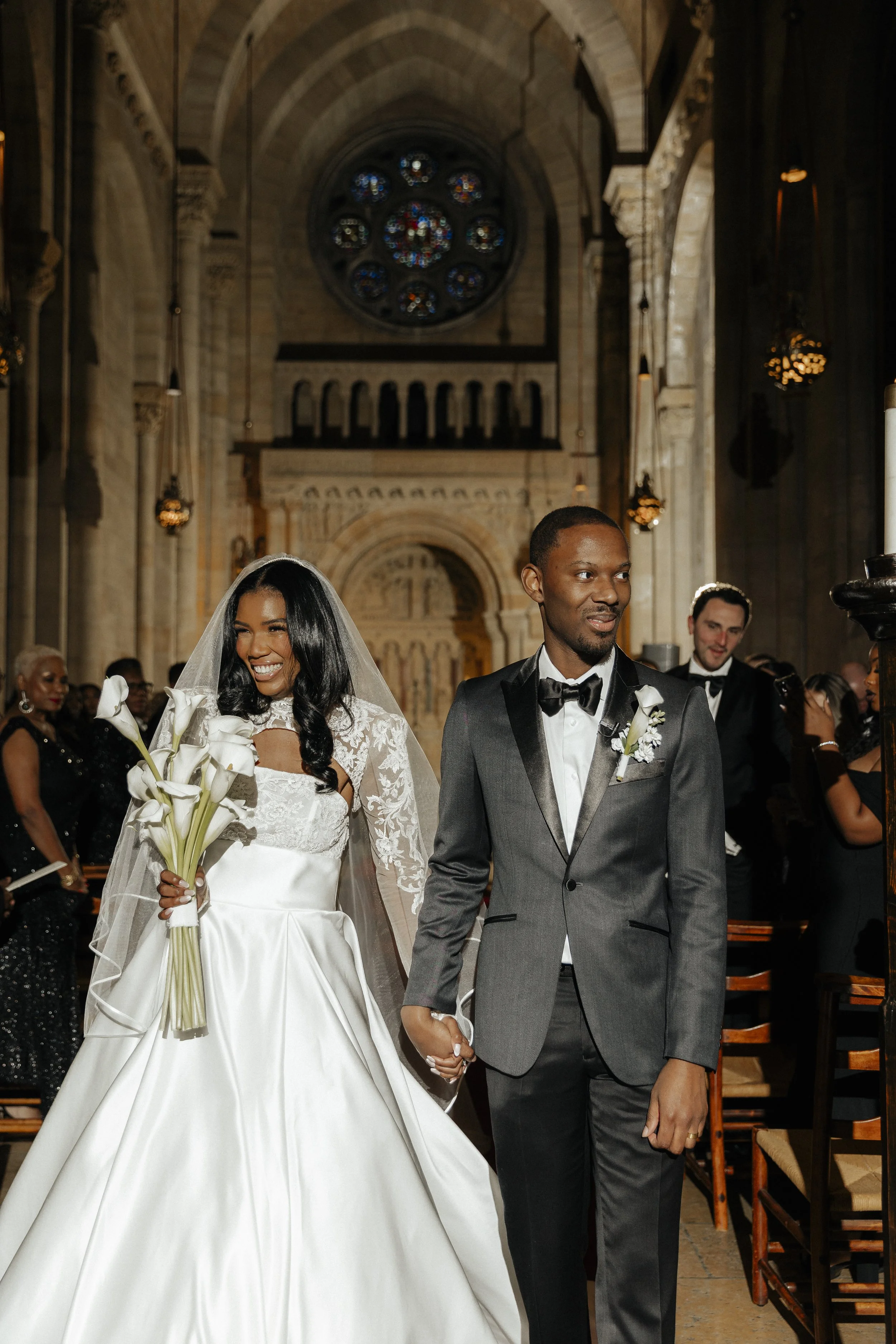 Wedding ceremony in a gorgeous church, bride is carrying long stem calla lily bridal bouquet