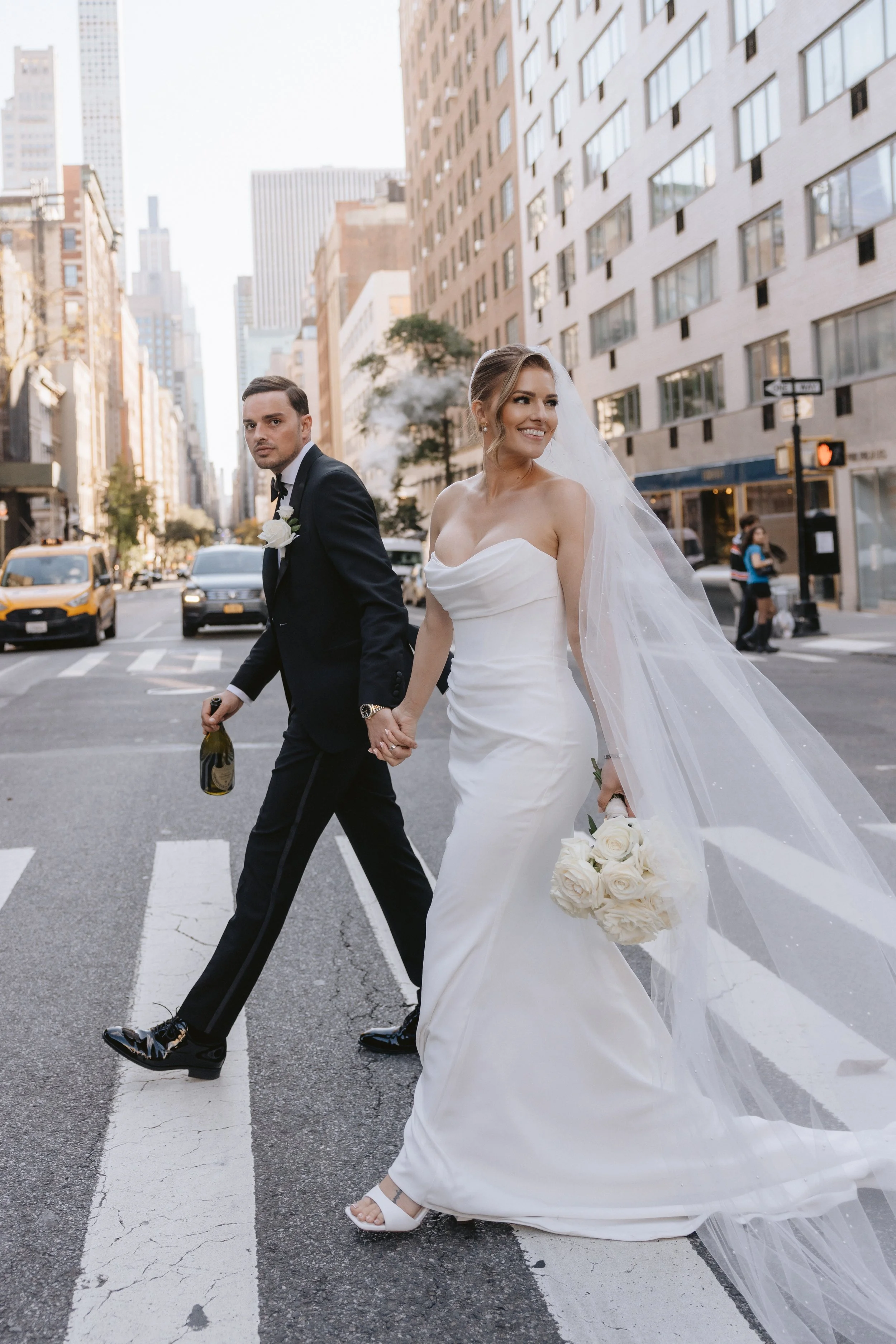 Beautiful couple on their wedding day in New York, bride carries classic but modern bouquet of white roses