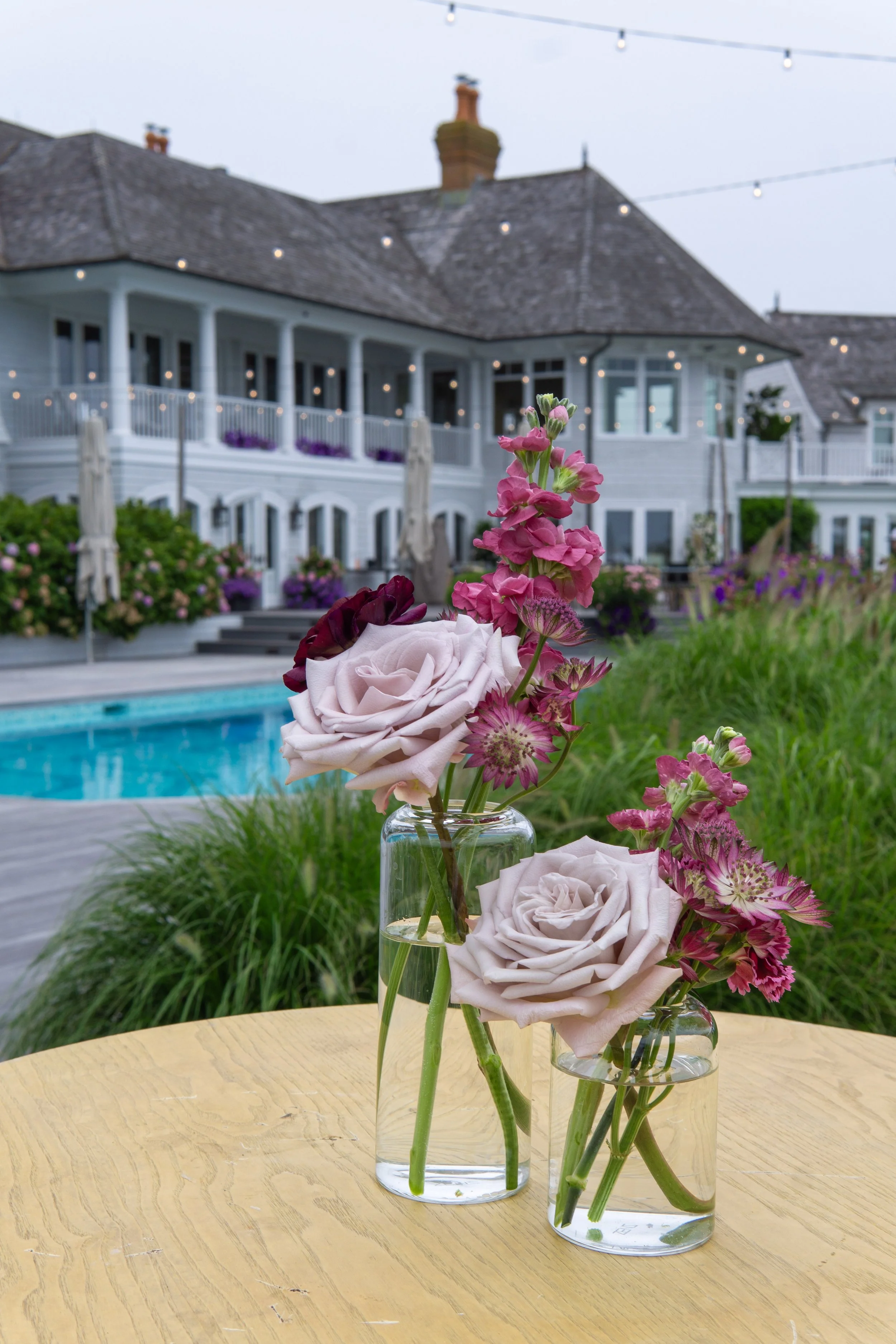 Pink and purple flowers in glass bud vases in Hamptons