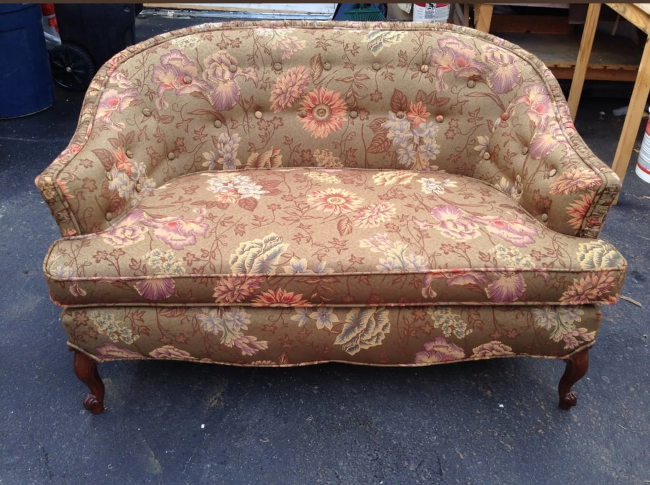 Antique loveseat with buttons reupholstered in a vintage floral fabric. 