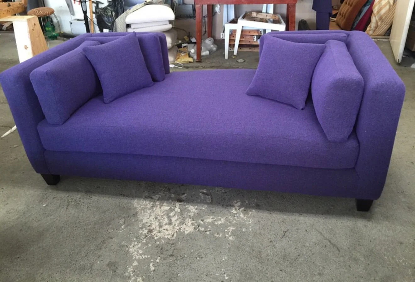 Mid-century sofa upholstered in a purple chenille fabric with loose cushions for the seat and back.