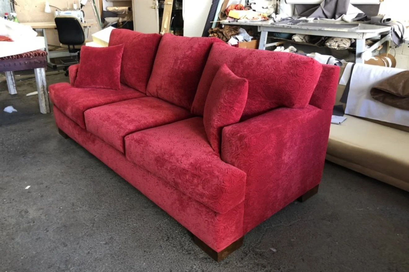 Loveseat reupholstered in a red velvet with loose seat and back cushions. 