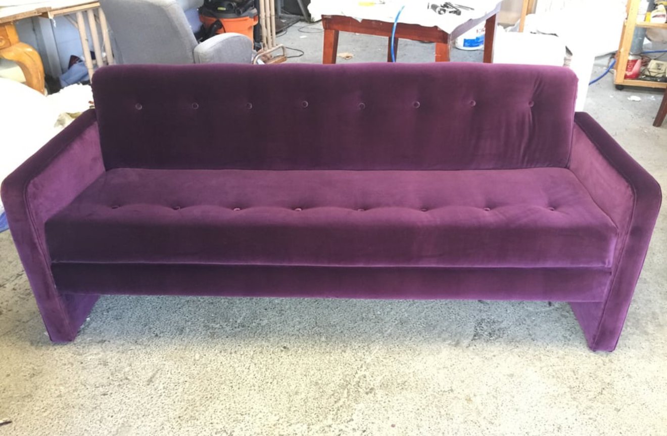 Button tufted mid century style sofa reupholstered in a purple velvet. 