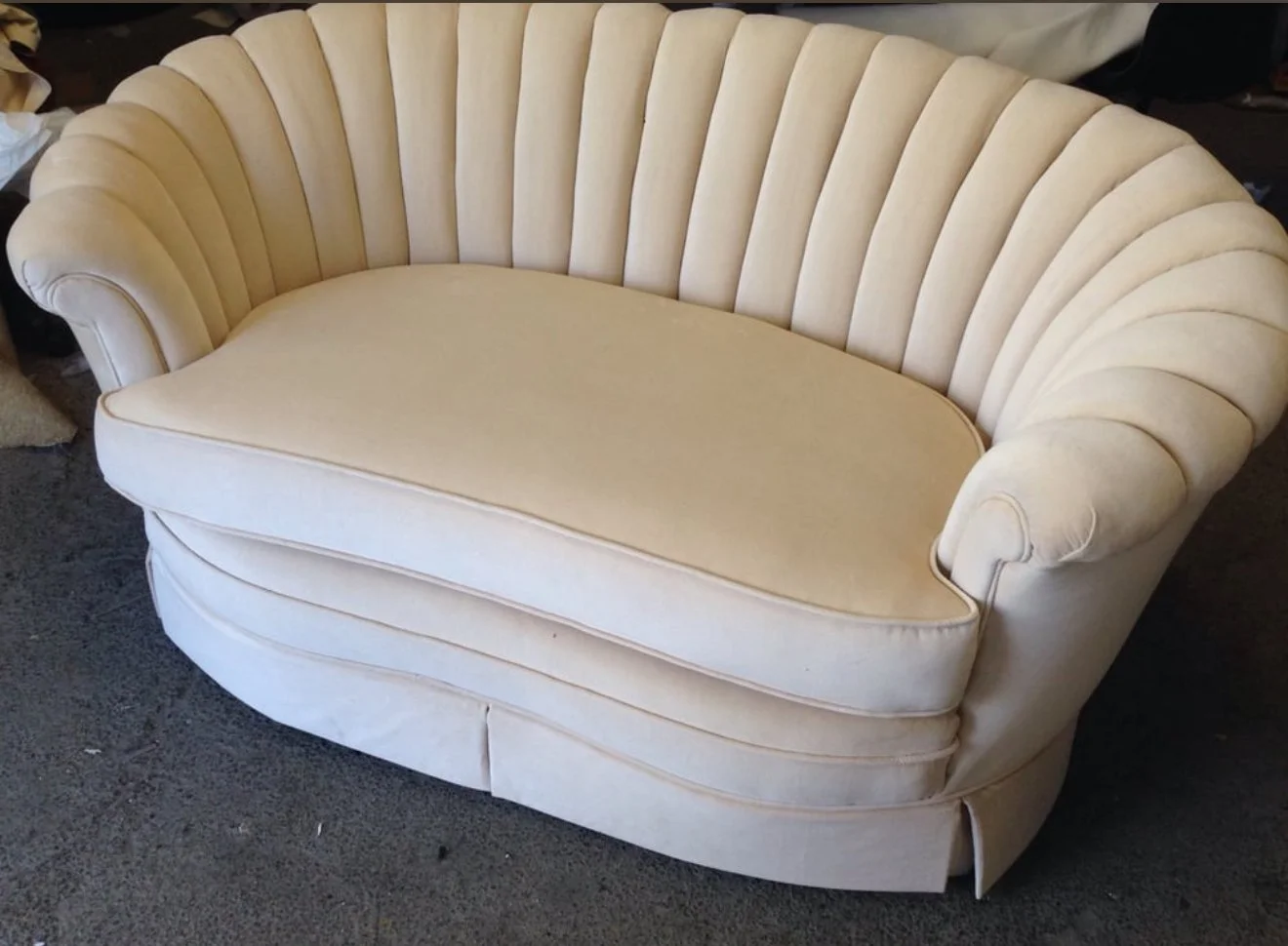 Seashell style channel-back loveseat upholstered in a white velvet. 
