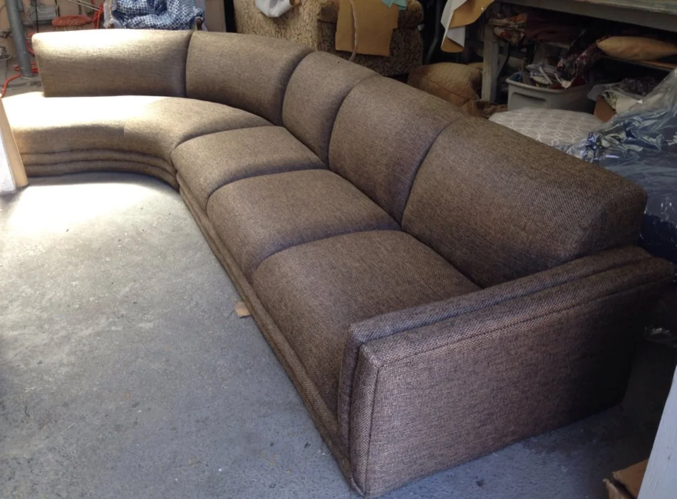 Curved sectional reupholstered in a brown performance fabric.