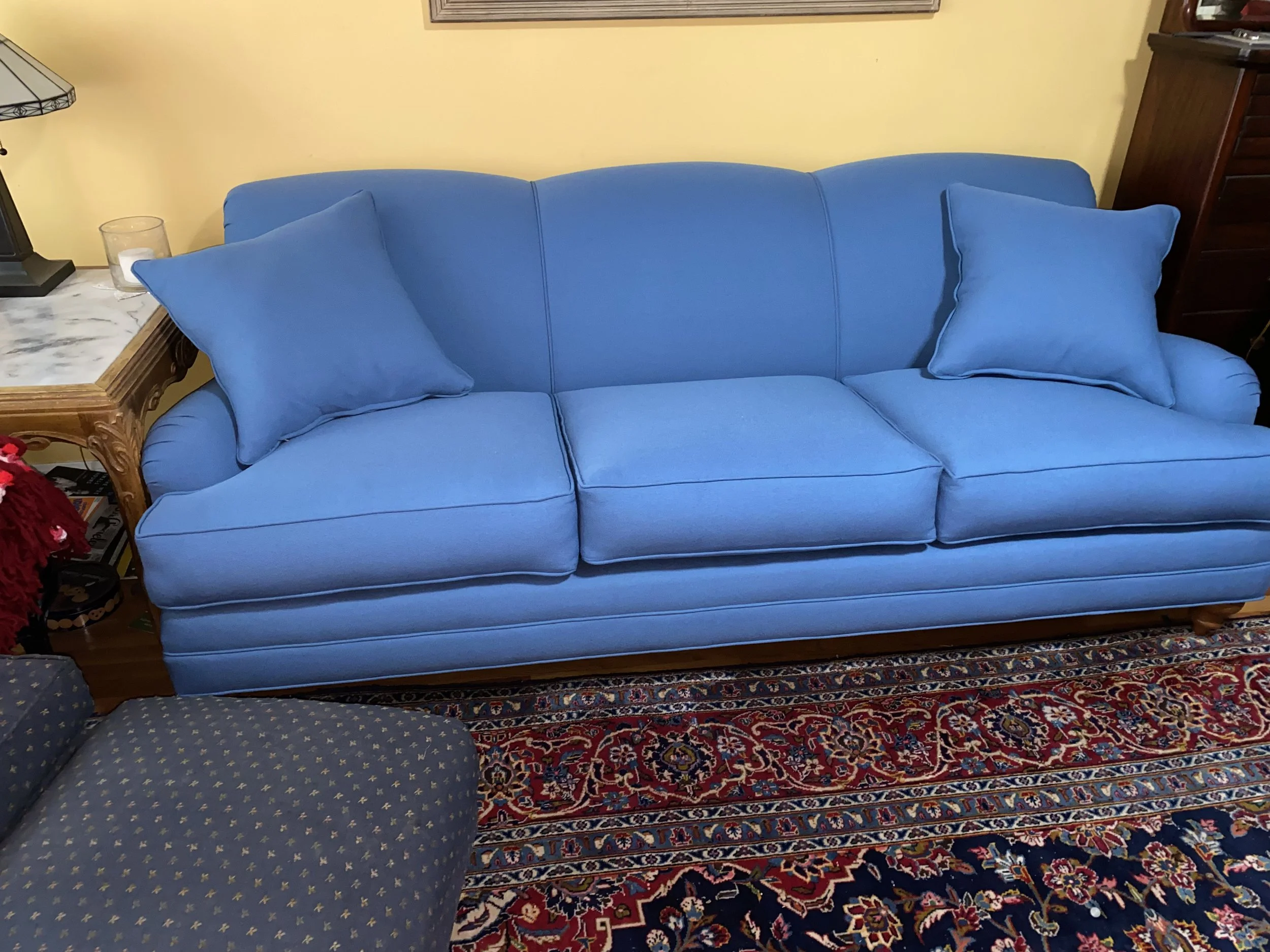 Traditional sofa reupholstered in a blue sunbrella fabric with new foam cushions and accent pillows. 