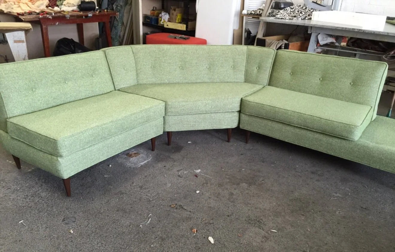 Mid century sectional with buttons and loose cushions upholstered in mint green performance fabric. 