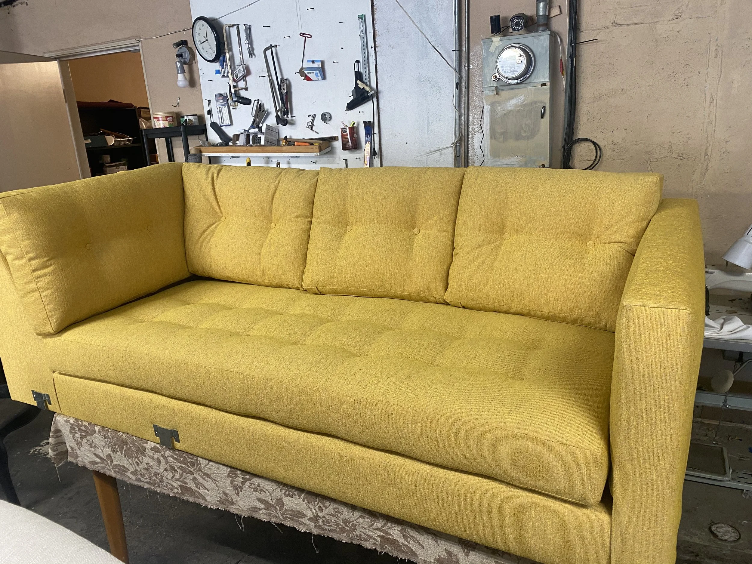 Pull-out bed loveseat reupholstered in a yellow chenille fabric.