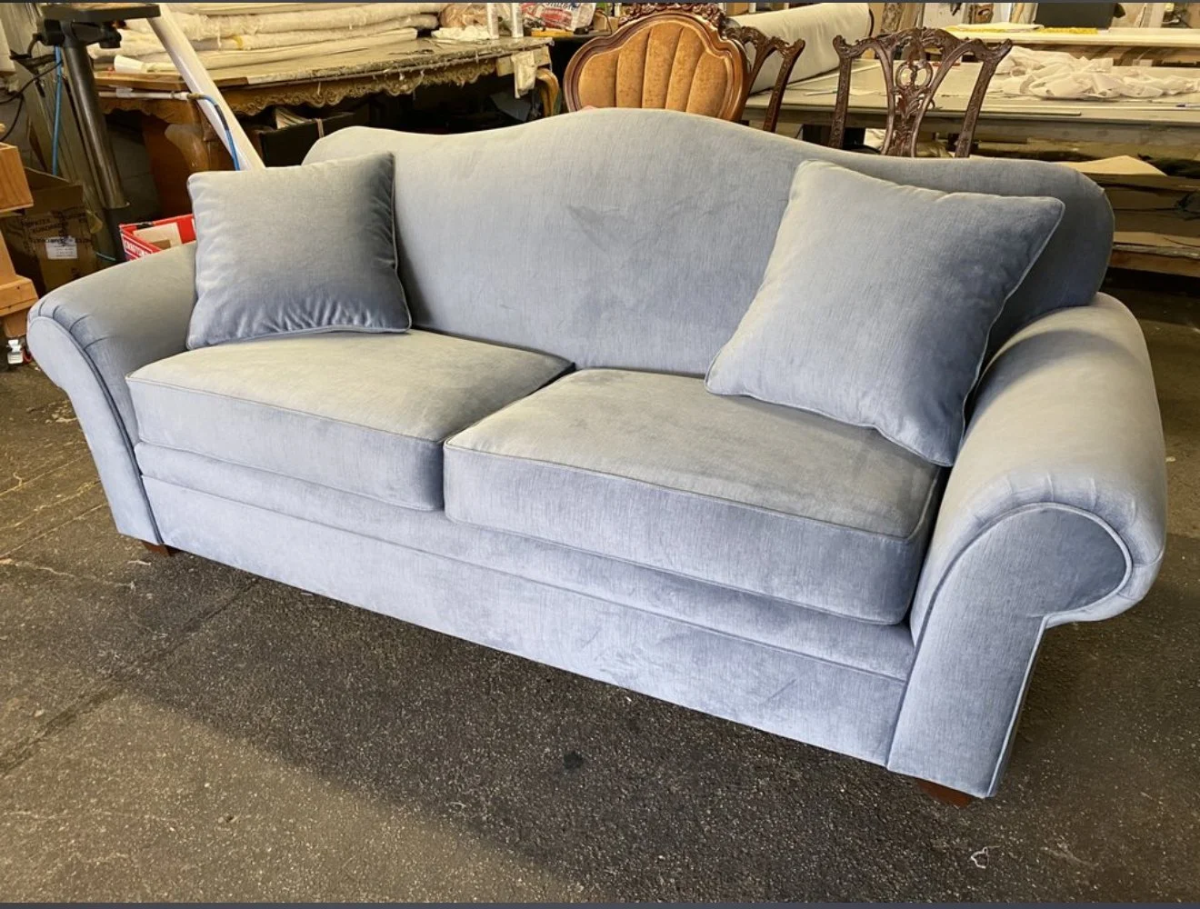 Grey loveseat upholstered in a grey performance velvet fabric. 