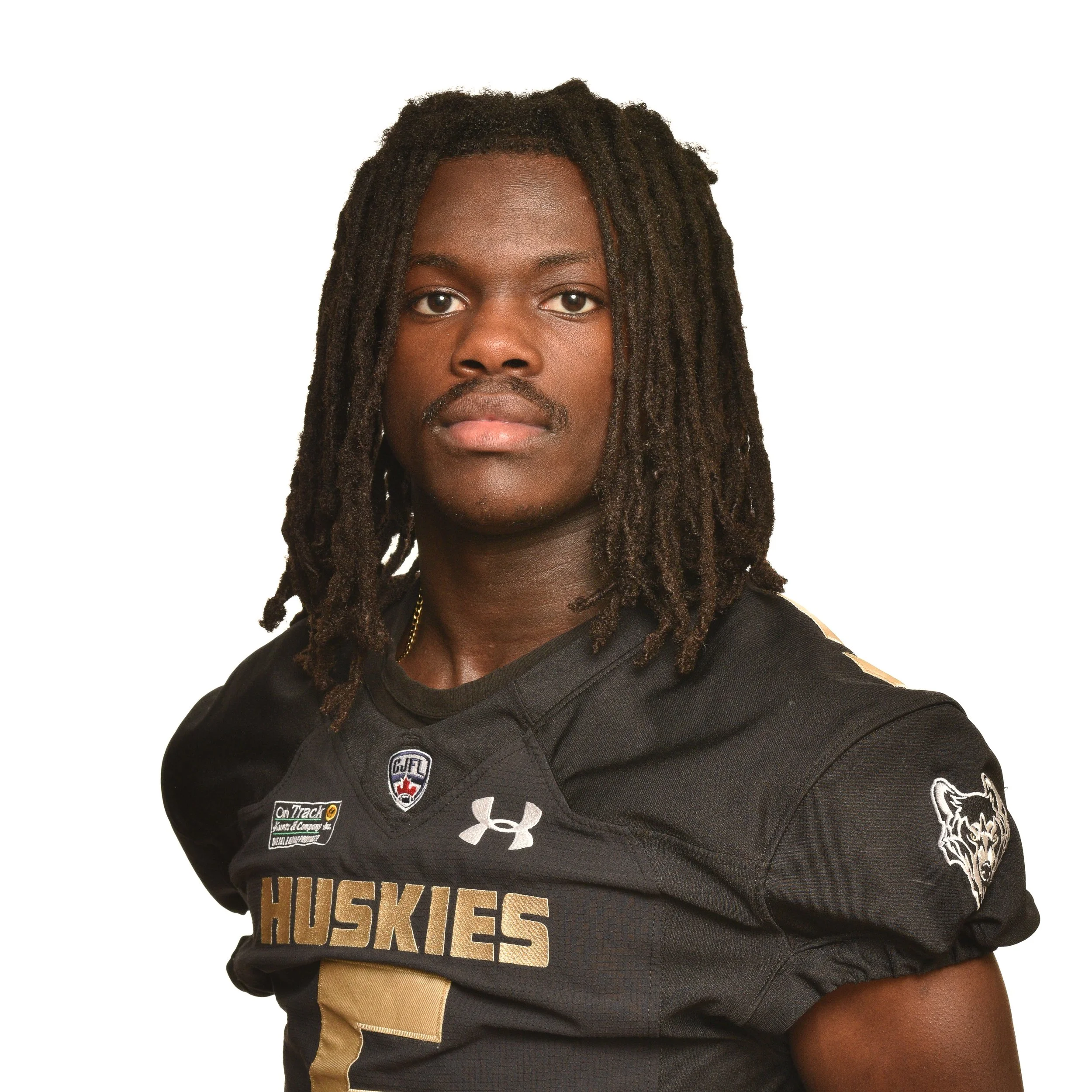 A football player in a black jersey with gold lettering and number 51, standing with a serious expression.