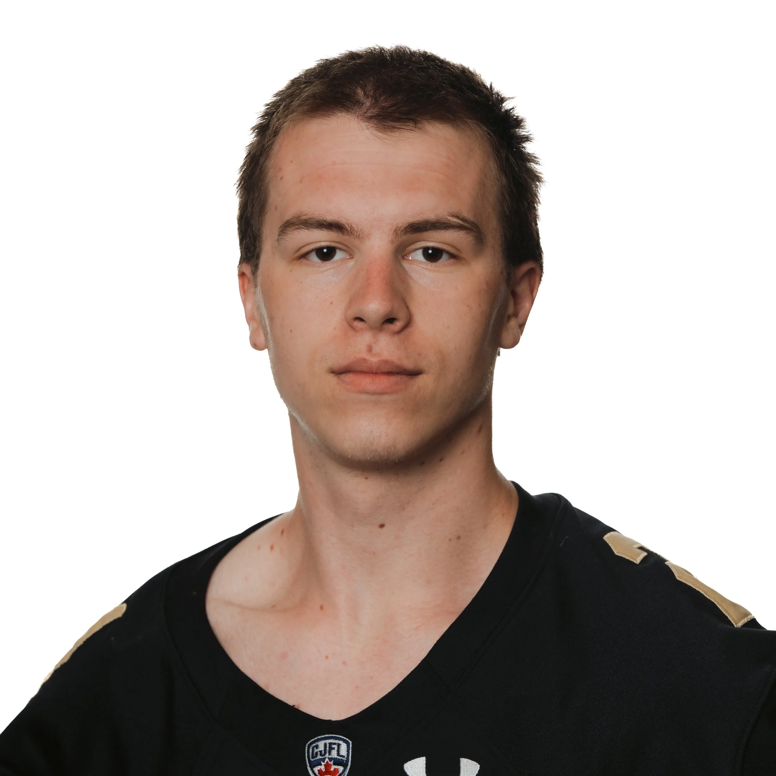A young man in a black football jersey with Huskies and Canadian Football League patches, smiling with shoulder-length brown hair, against a white background.