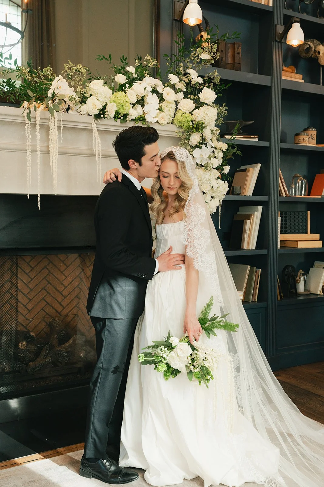 Design from Denver Wedding Florist, wishflower farms, a green and white theme with a large garland over the large fireplace at hotel teatro